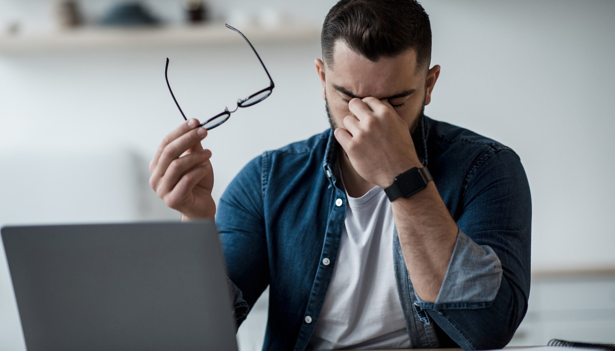 Individual experiencing stress and emotional exhaustion while working at a laptop, representing burnout, anxiety, overwhelm, irritability, and mental health counseling in McKinney, Texas.
