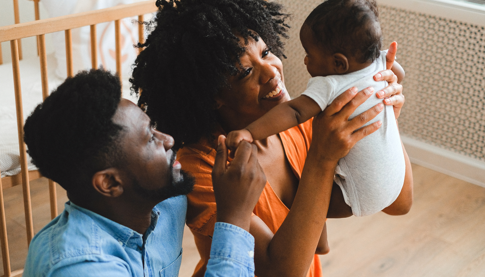 1. Parents holding their baby at home, representing the transition to parenthood, family changes, and therapy for major life transitions and new stages of life.