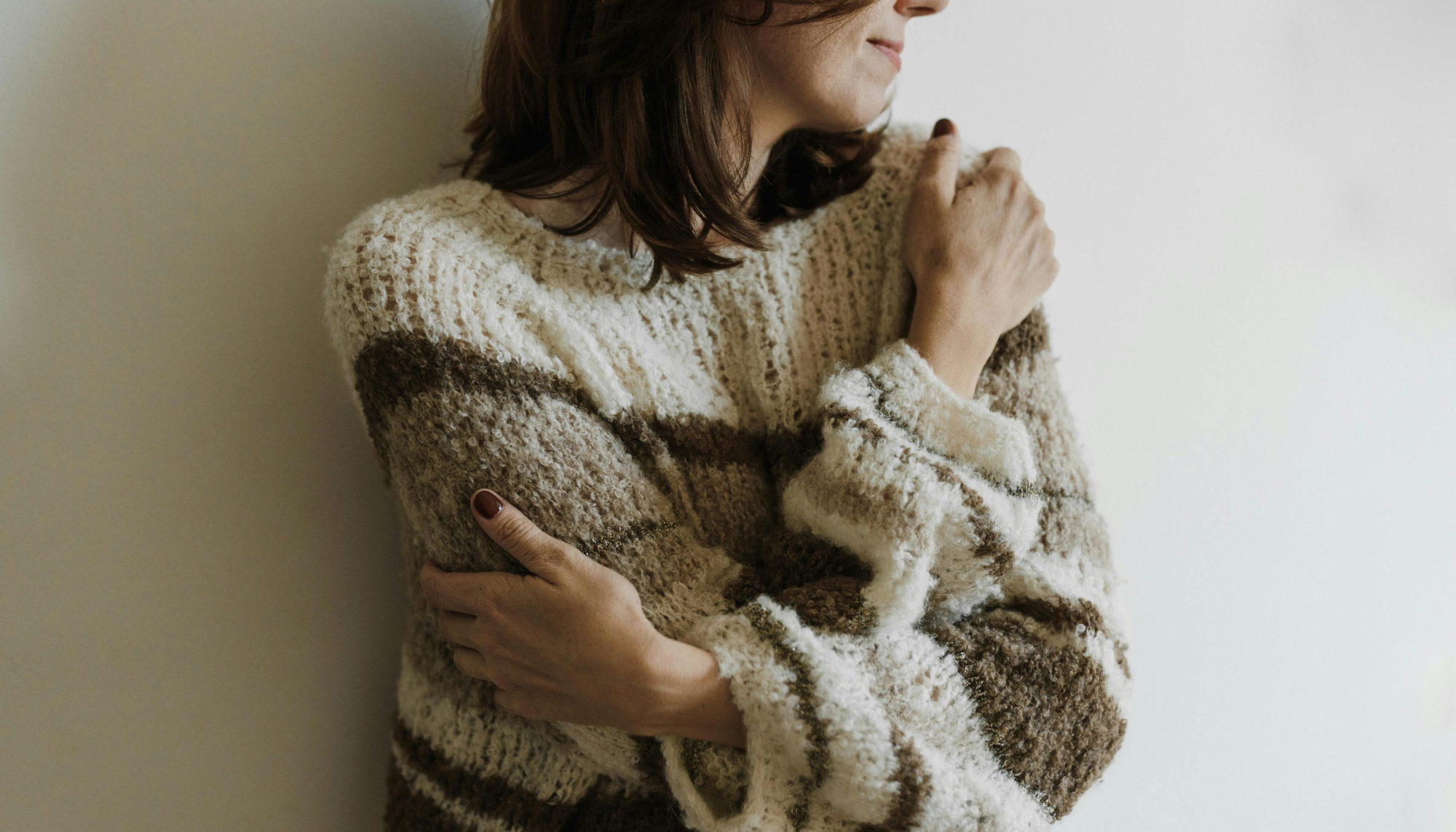 1. Woman holding herself in a comforting pose, representing low self-esteem, self-doubt, emotional support, and therapy for building confidence.