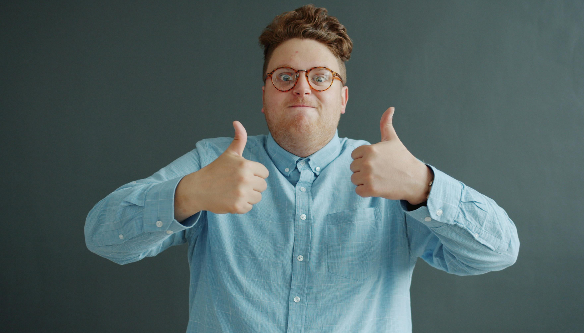 Young adult giving a thumbs up representing confidence, support, and neurodivergent affirming therapy for ADHD and autism at Sharp Wellness.
