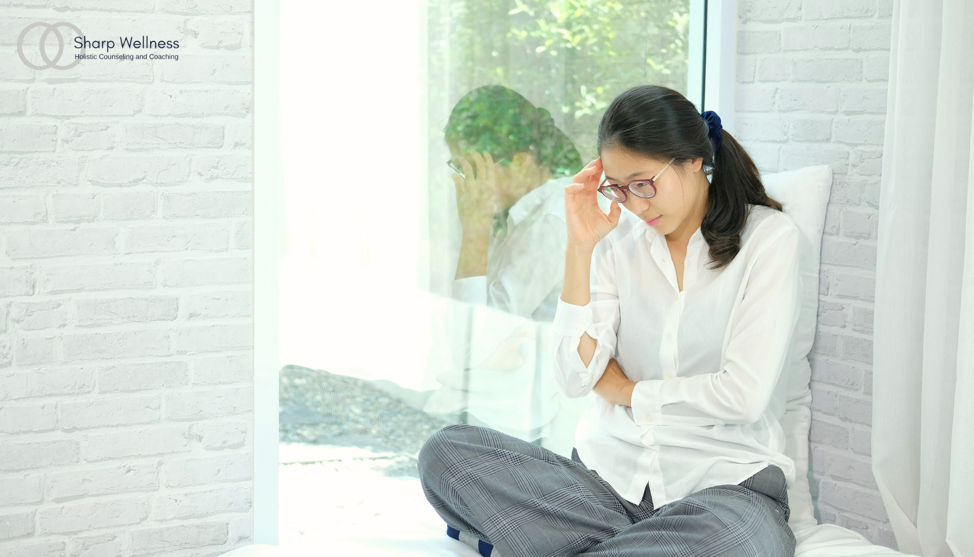 Woman sitting by a bright window with a thoughtful expression, symbolizing racing thoughts, chronic stress, overthinking, anxiety, mental fatigue, and emotional wellness in McKinney, Texas.