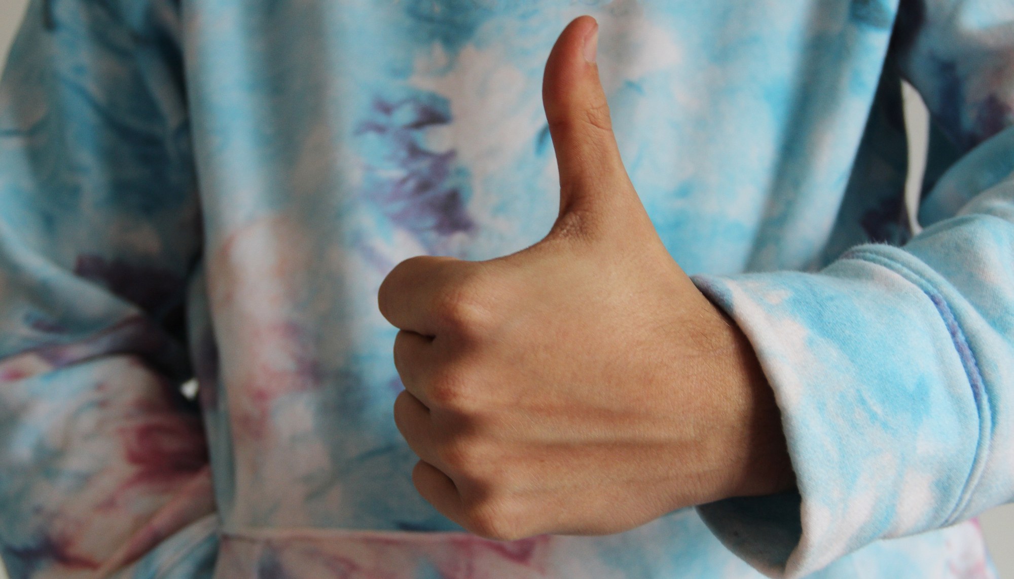 Person giving a thumbs up, representing emotional masking, saying “I’m fine,” people pleasing, and therapy support in McKinney, TX.
