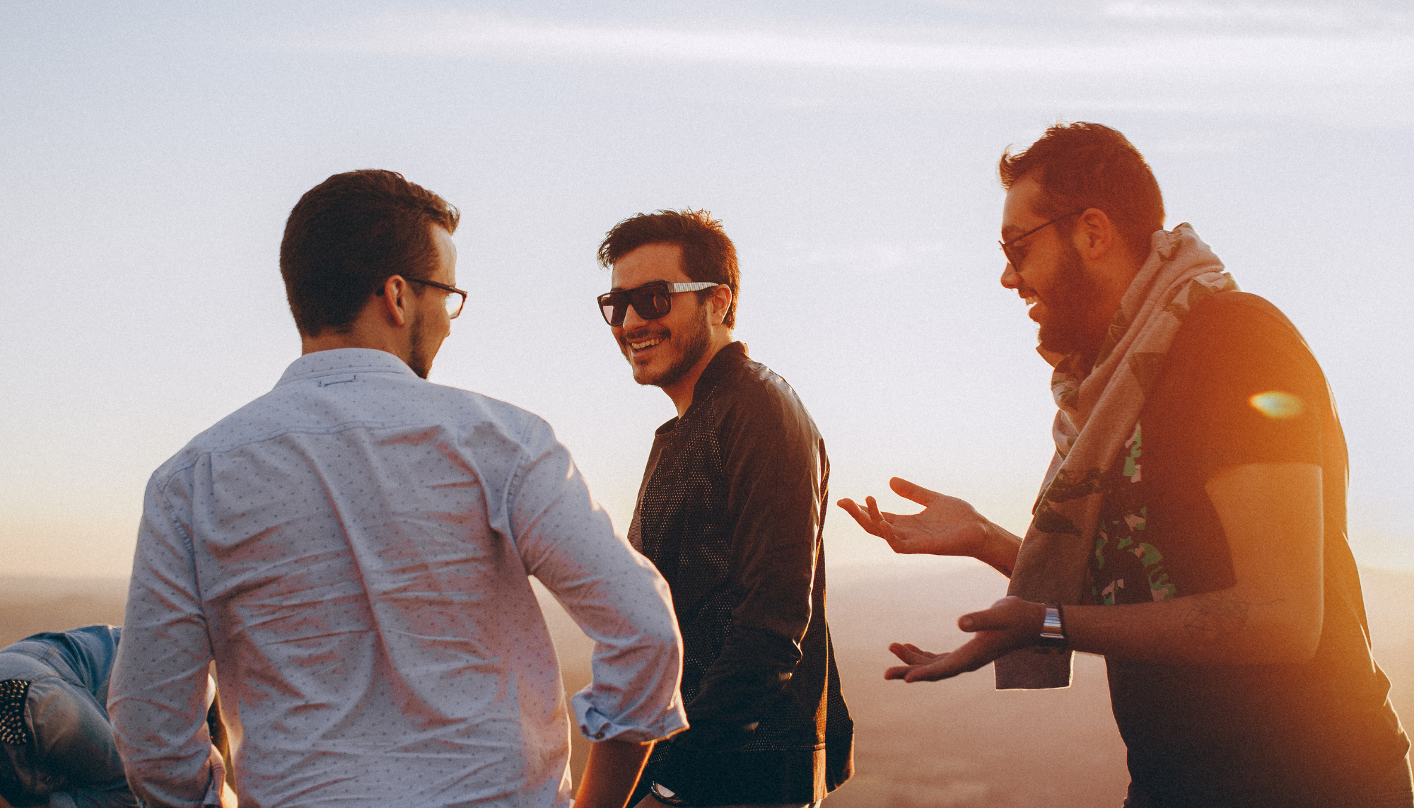 1. Group of male friends talking outdoors, representing men’s mental health support, social connection, stress management, and emotional well-being.