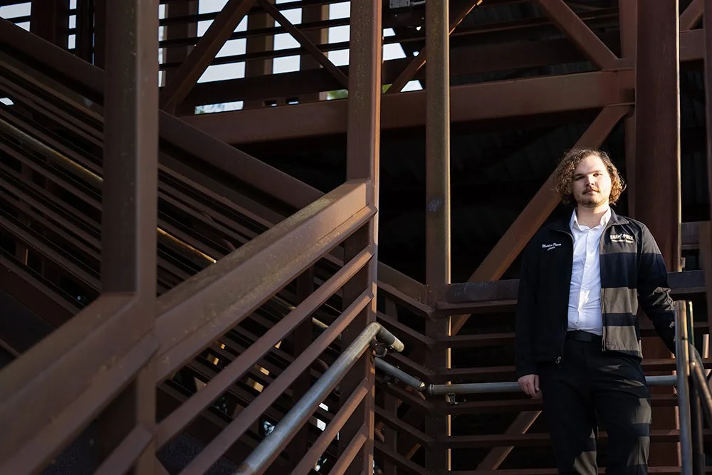 Cal poly graduate standing on stair staircase in San Luis Obispo County California