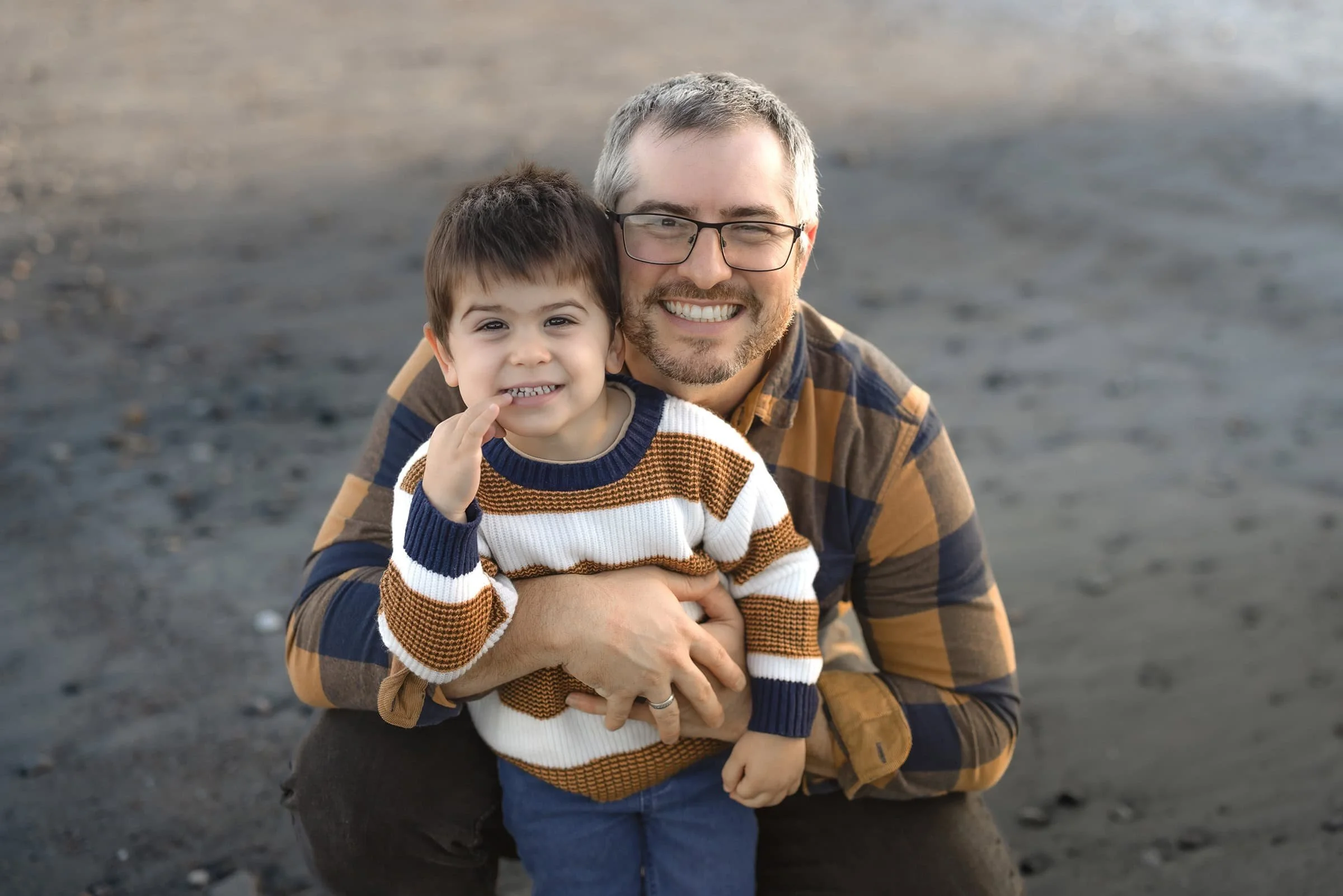 Father and son walking together on Avila Beach at sunset