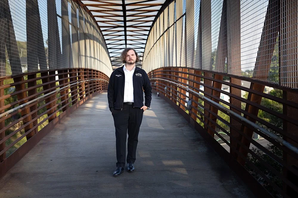Call poly grad standing on Trubridge in San Luis Obispo, California during golden hour
