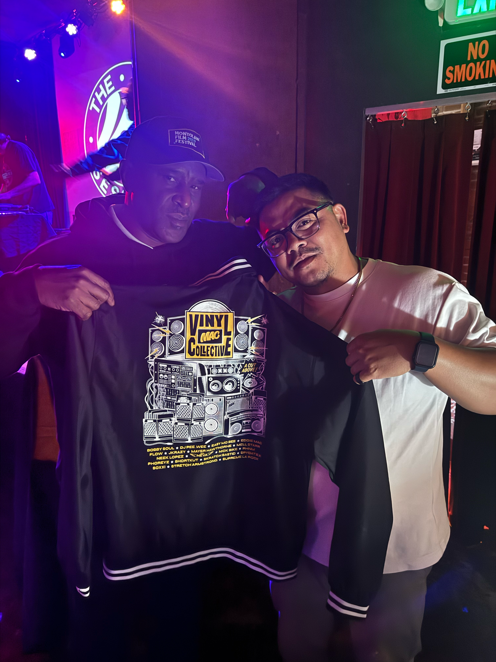 The 45 Sessions opening for Easy Mo Bee holding up the Mac Agency Crew jacket 