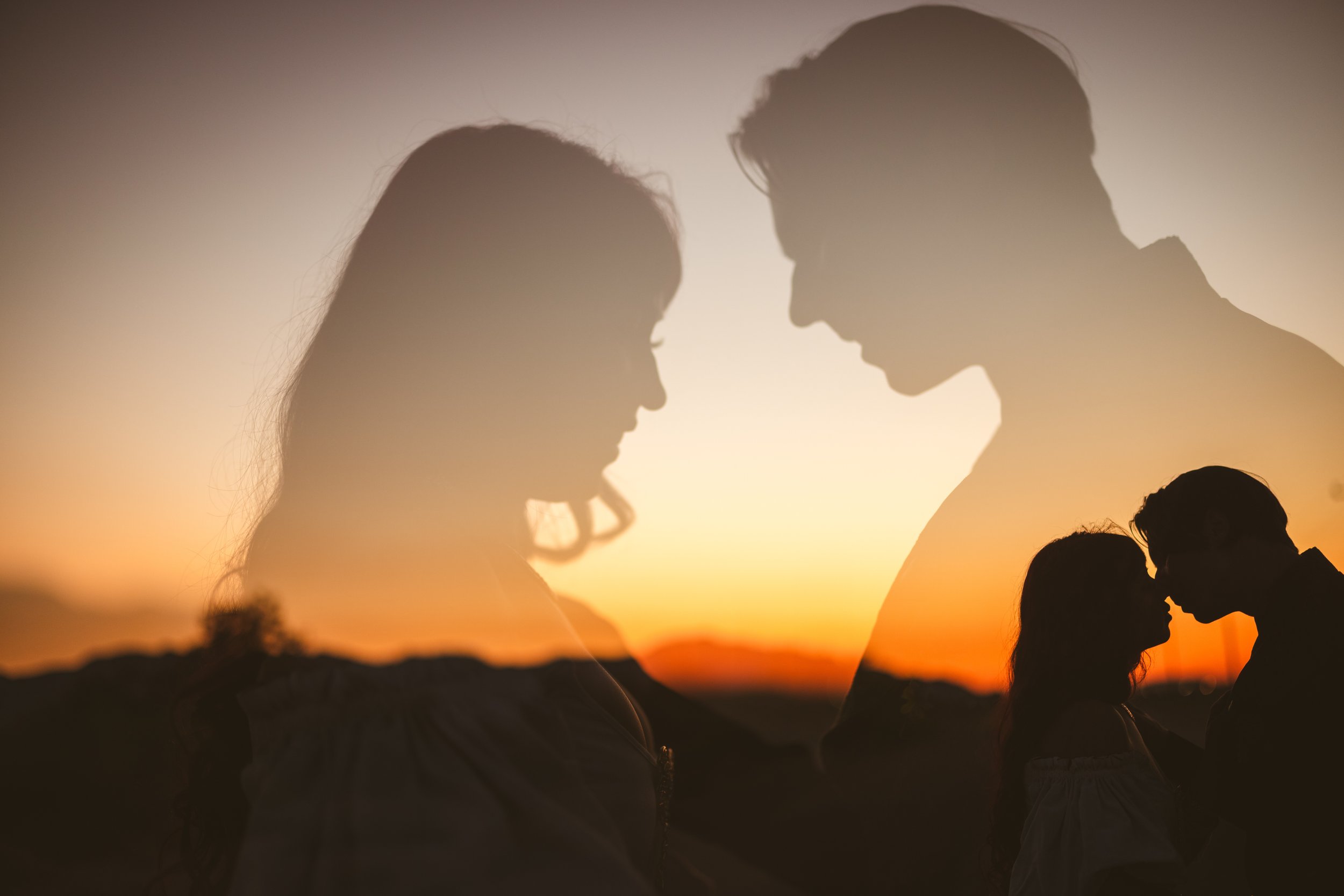 Silhouettes of a couple touching foreheads at sunset, with a double exposure effect showing the woman's face and the couple close together, set against a colorful sunset sky.