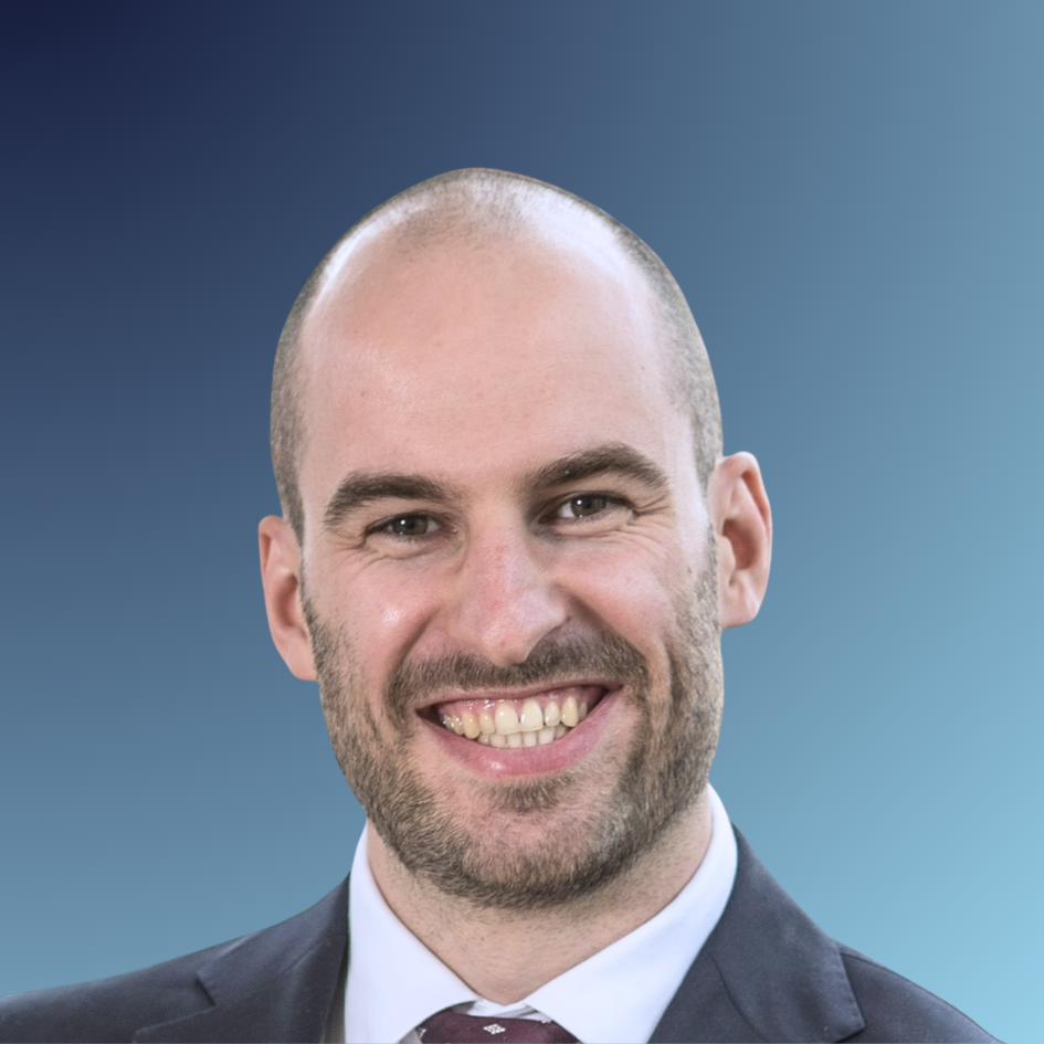 Portrait of a smiling man in a suit and tie, indoors.