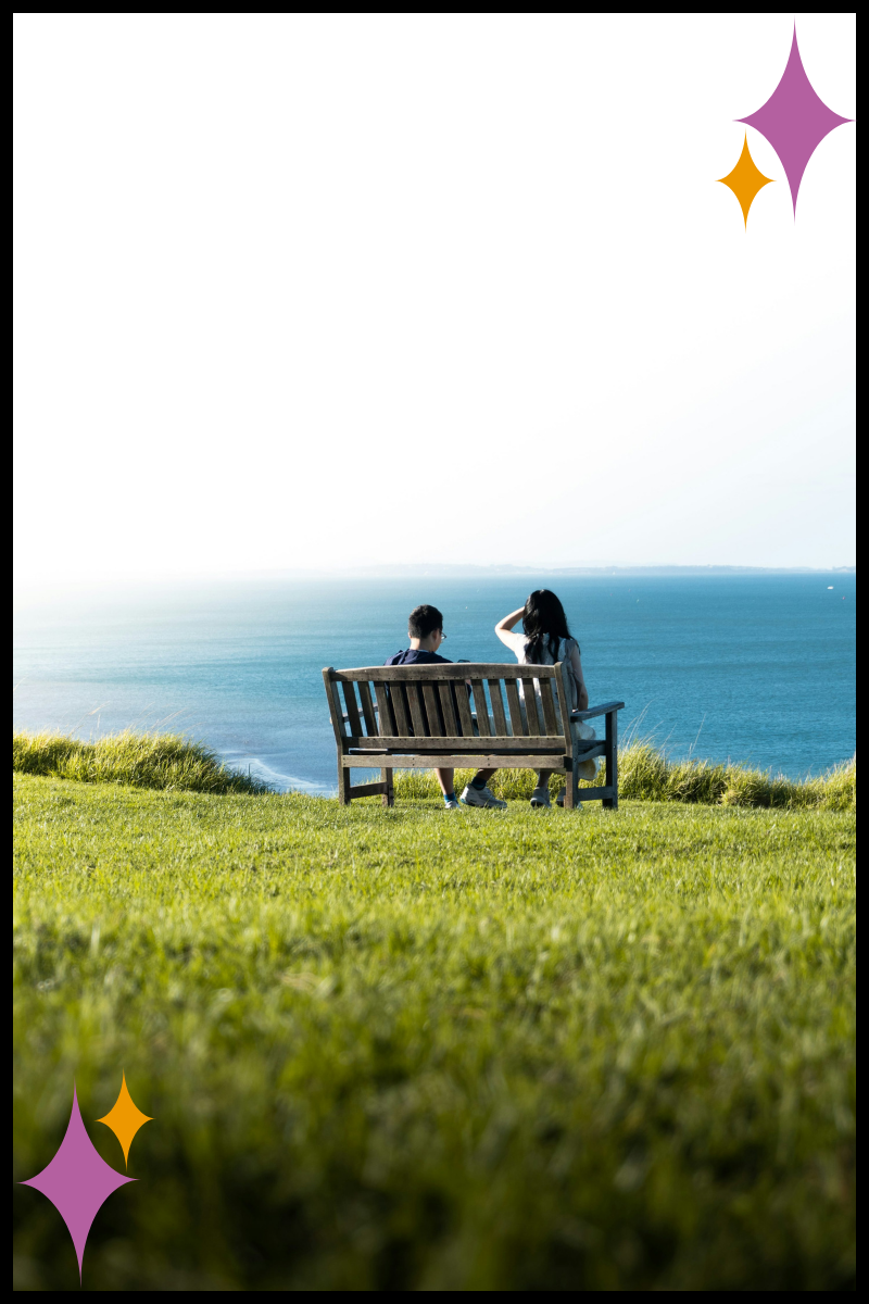 Two people sitting together overlooking a landscape, symbolizing shared healing and human connection.