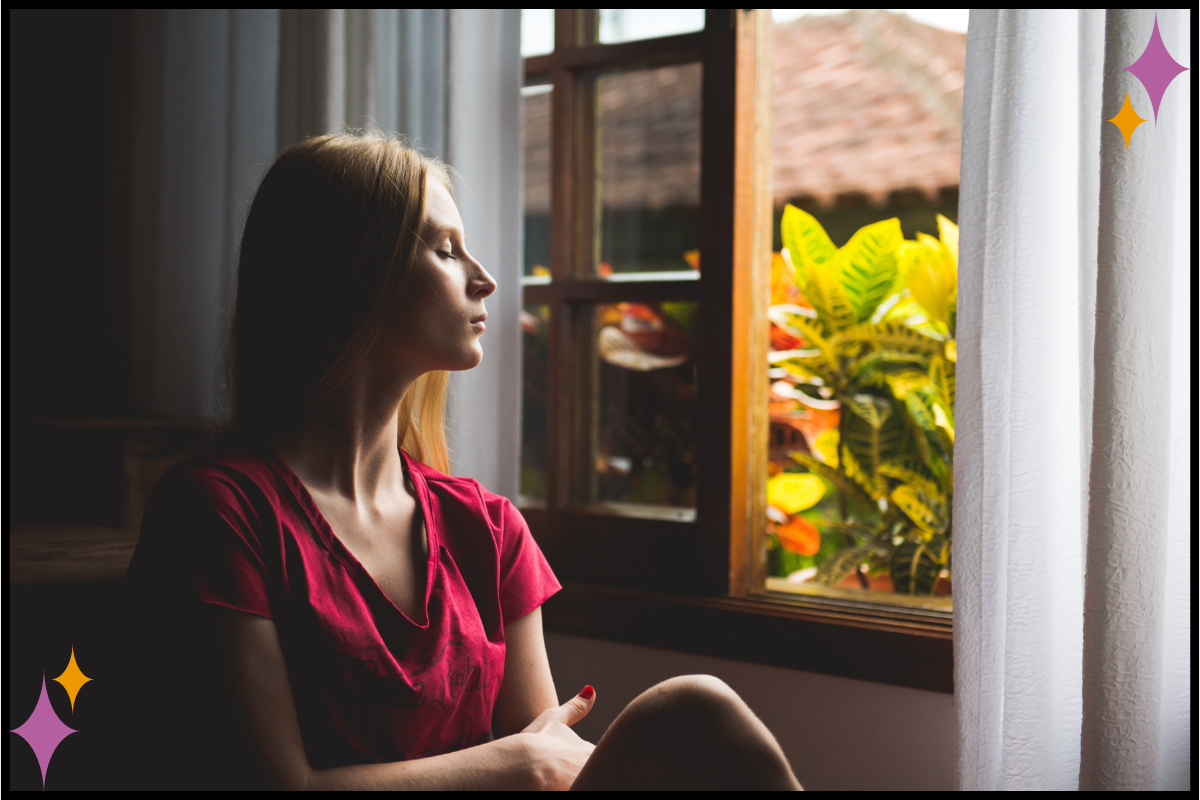 A person sitting quietly by a window, pausing before making a decision.