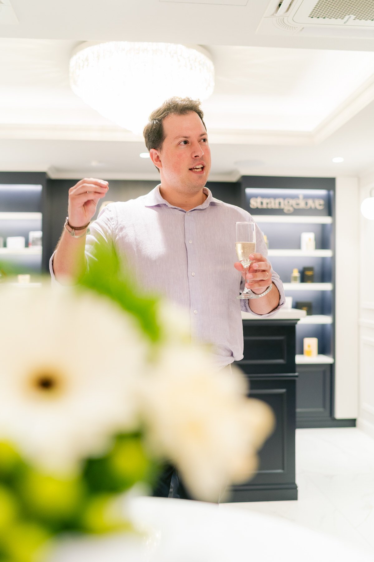 Hombre en una celebración, con copa de champagne, en un interior elegante.