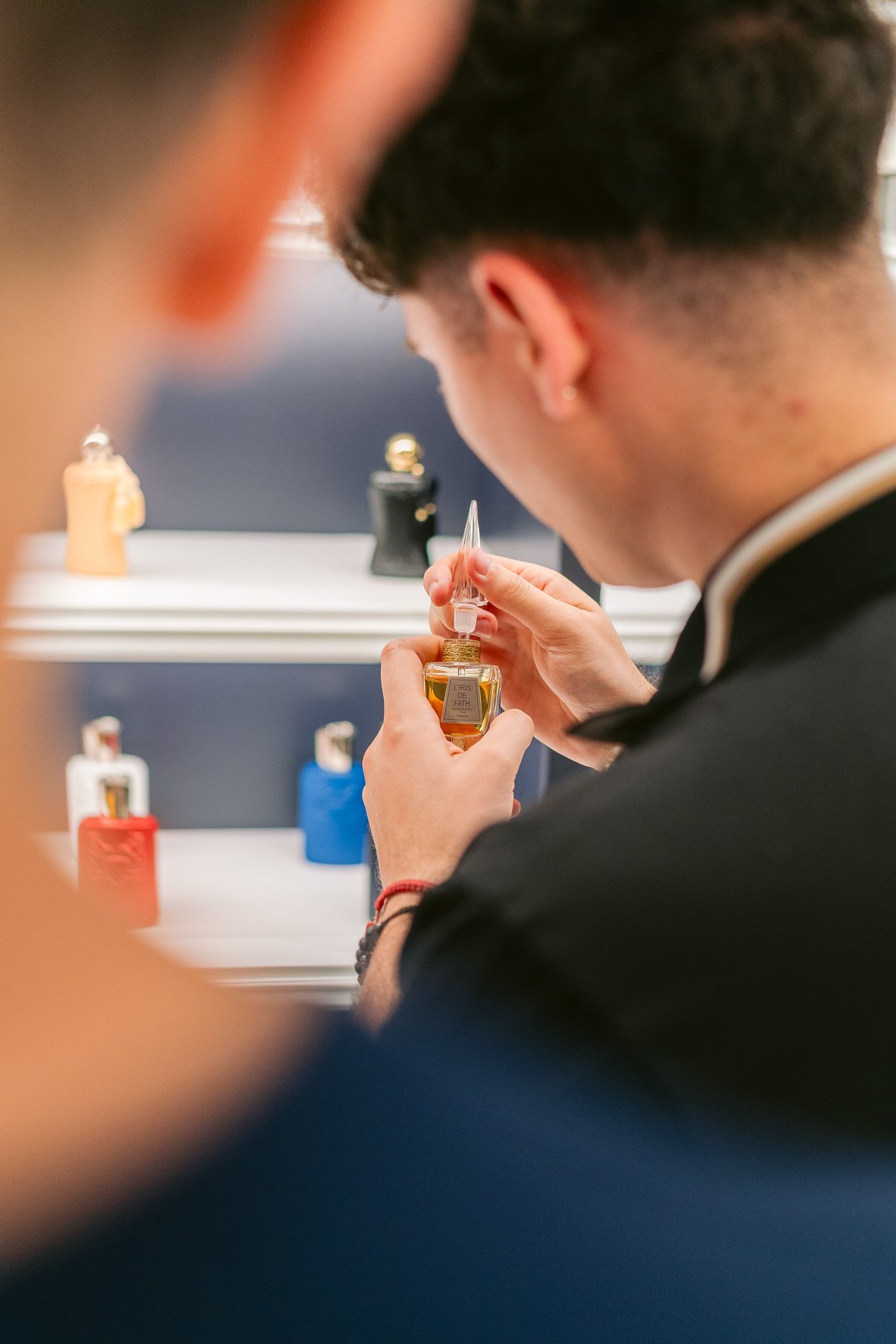 Persona examinando frascos de perfume en una tienda.