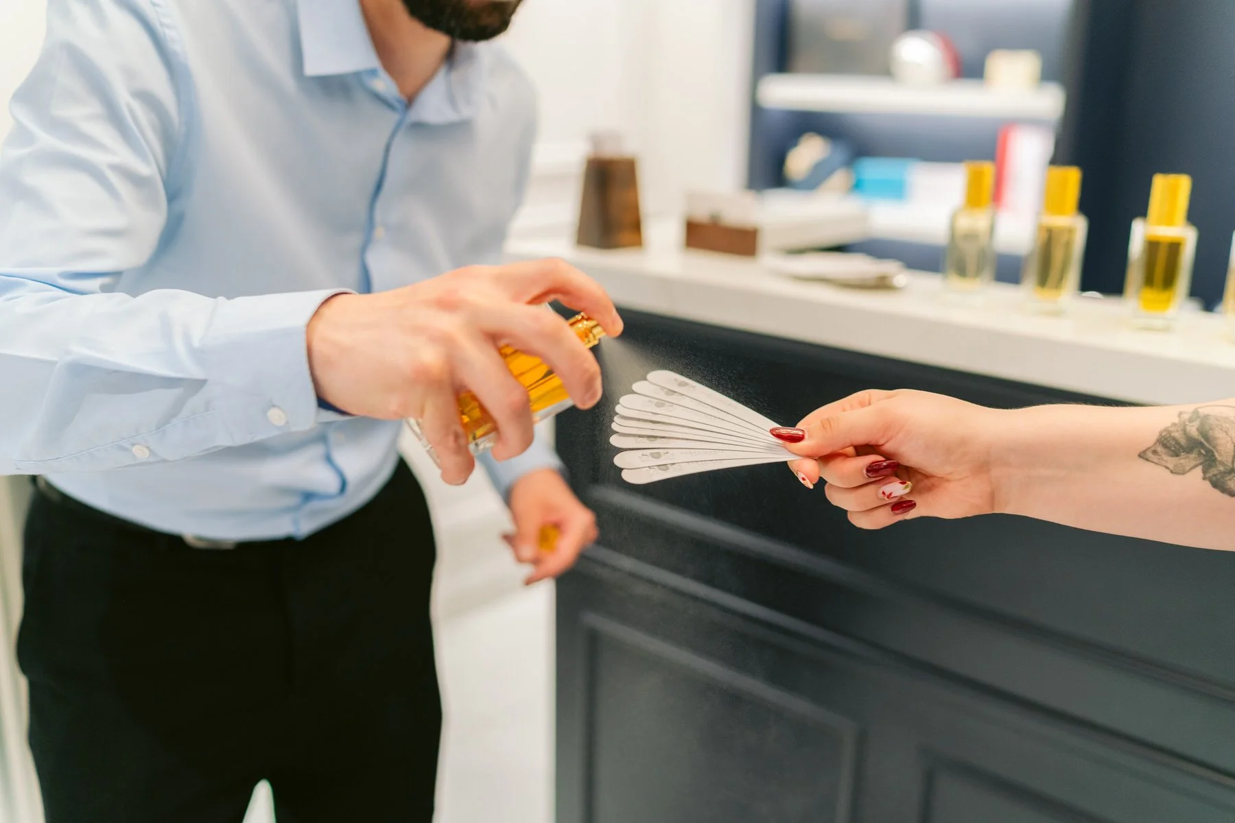 Persona aplicando esmalte en uñas de otra persona en un salón de belleza
