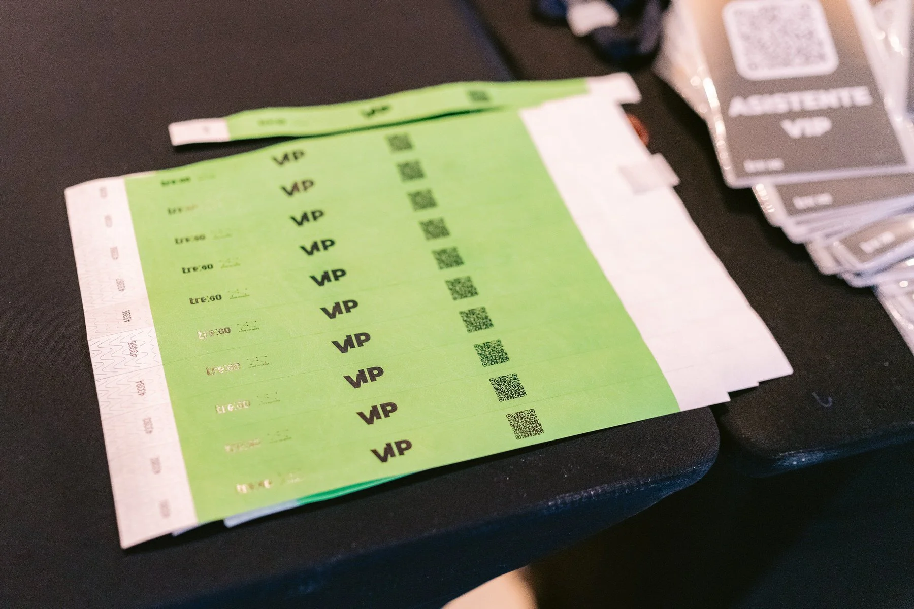 Pasajes de avión en color verde con código QR y etiquetas VIP sobre mesa negra.