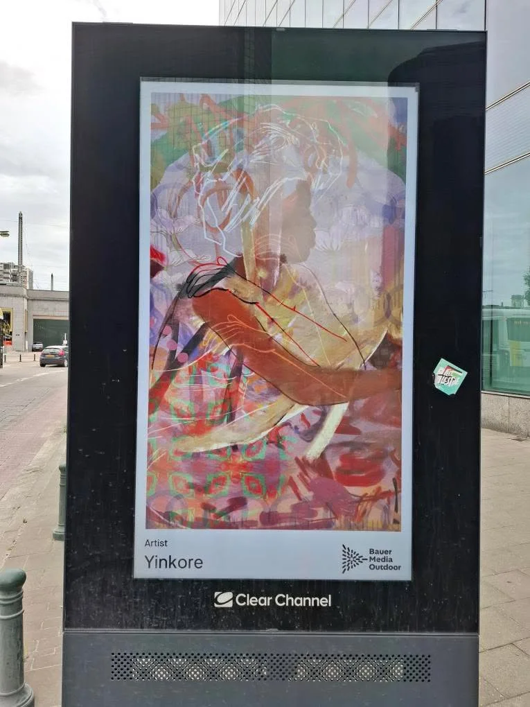 Colorful, abstract digital artwork of a woman with curly hair, wearing headphones, and engaged with a tablet or device. Art by Yinkore, displayed on a digital billboard.