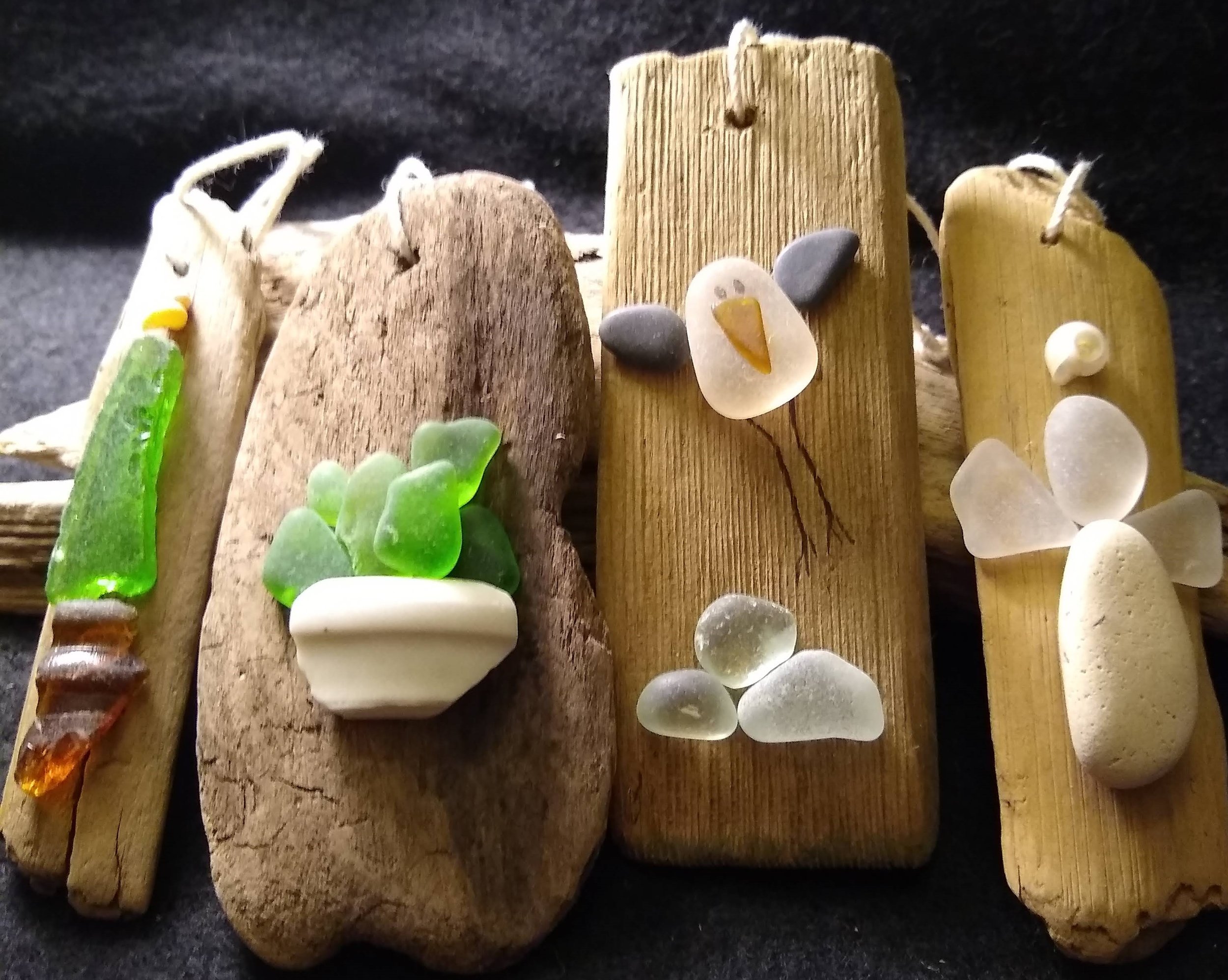 Fun driftwood ornaments created with beach glass, stone, pottery and shells.