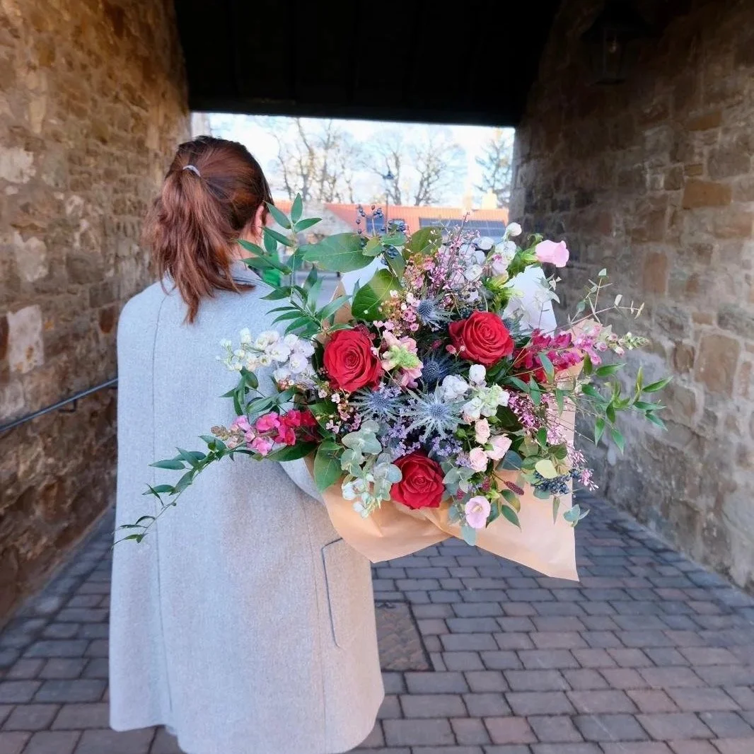 wild-valentines-bouquet-with-roses-and-thistles-wrapped-in-brown-paper-in-bloom-studio.jpg