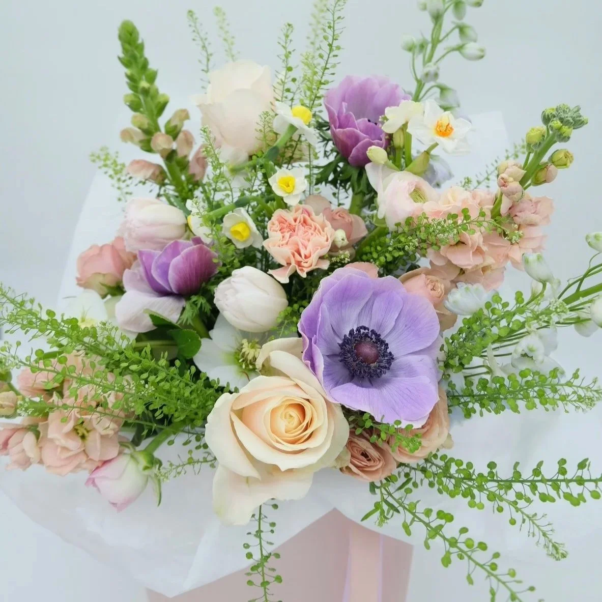 Scents-of-spring-mothers-day-bouquet-wrapped-in-tissue-and-pink-box-with-annemones-stocks-and-ranunculus.jpg