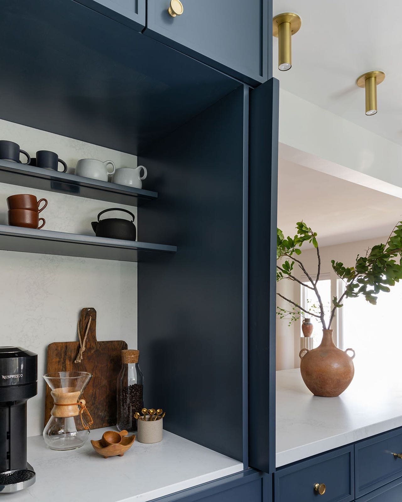 What design elements are an absolute must in your kitchen space? For coffee connoisseurs, a station dedicated to preparing the perfect cup was a top priority. We positioned this beloved spot behind recessed doors to keep things streamlined and unclut