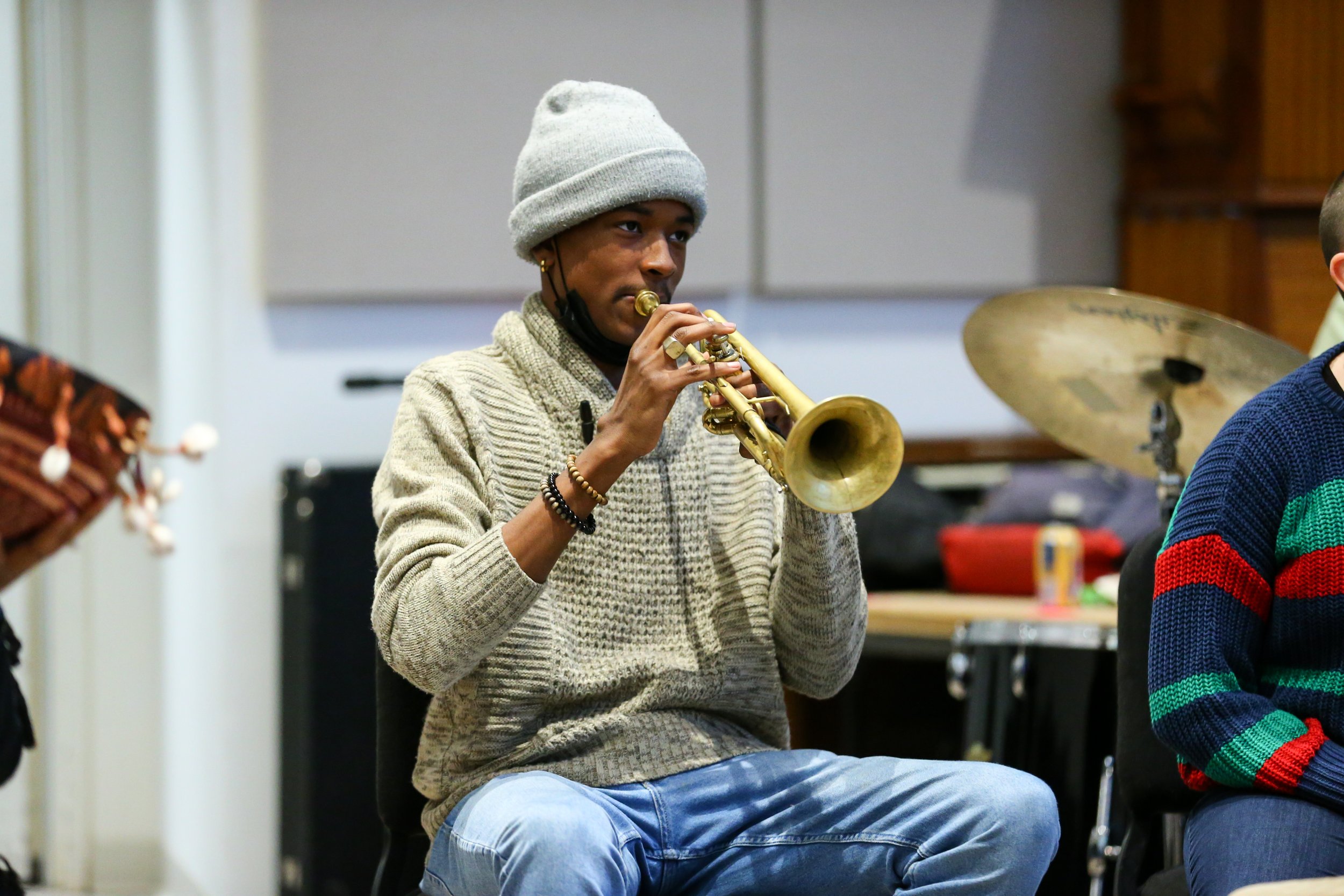 A student accompanies the ensemble on trumpet.