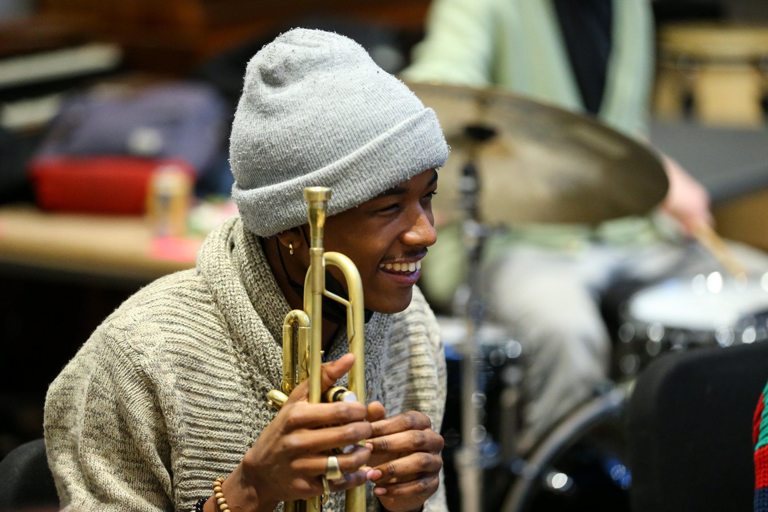 A student with a trumpet laughs during an ensemble rehearsal in a Woolworth Center classroom.
