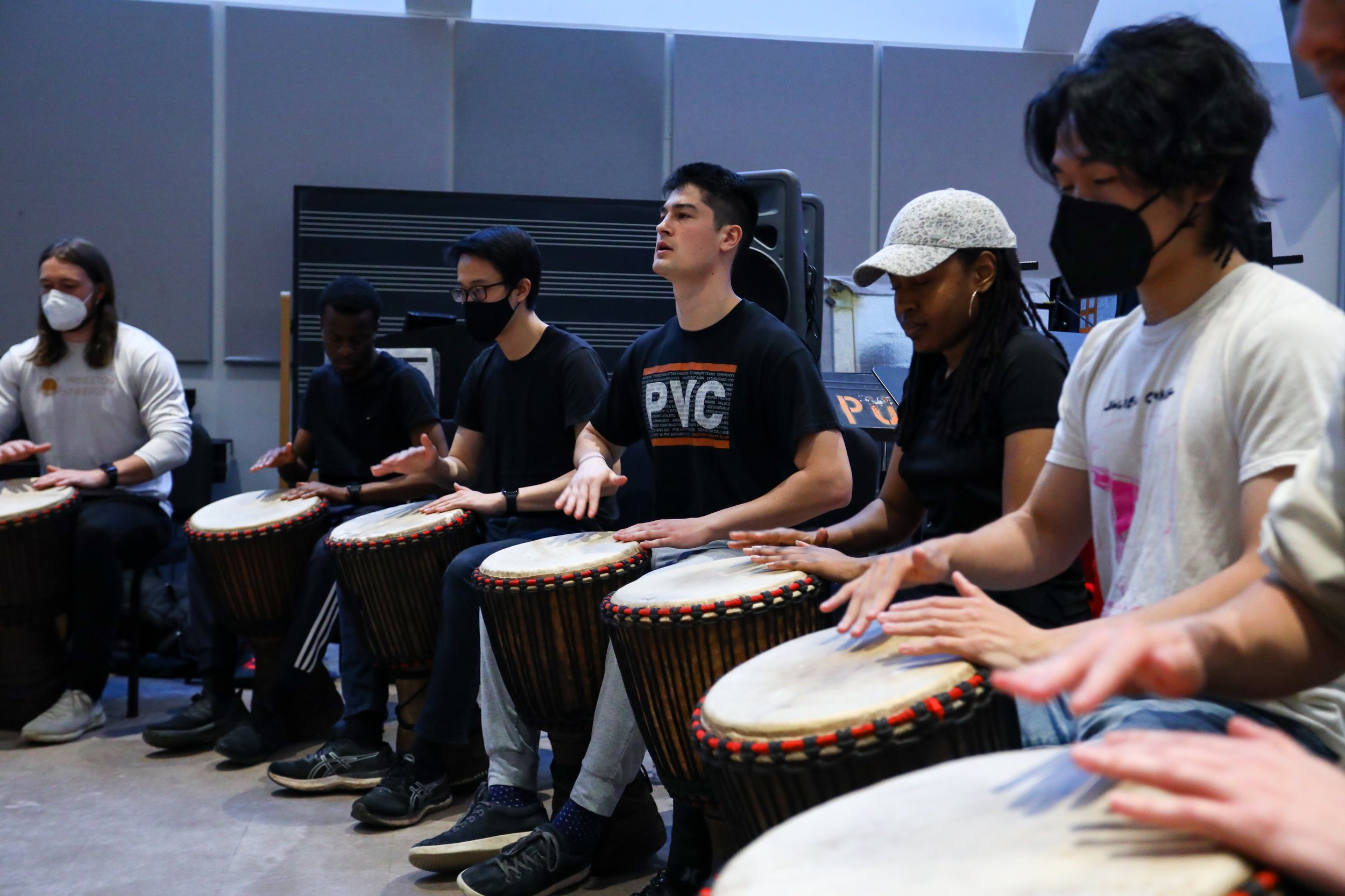 Students play the djembe drum in a Woolworth Center classroom.