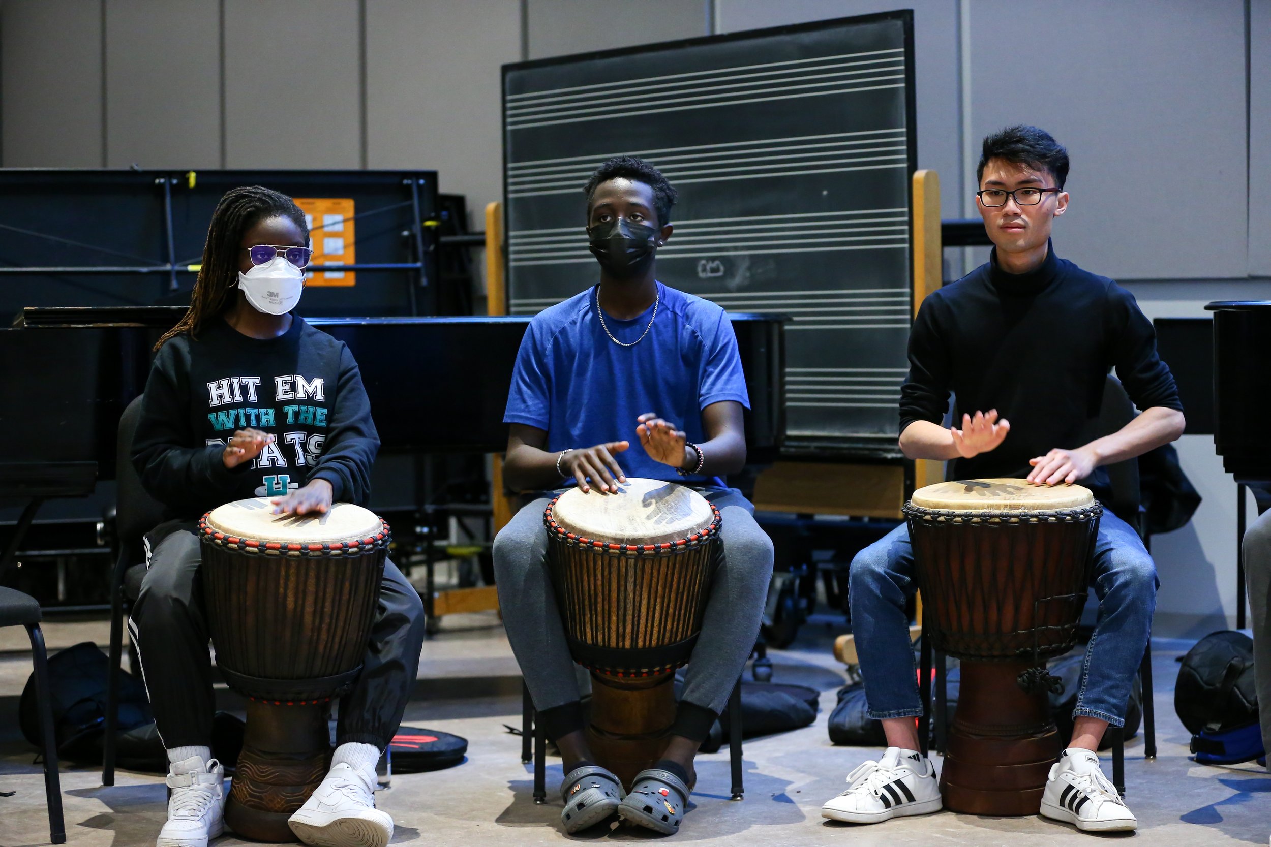 Students play the djembe drum in a Woolworth Center classroom.