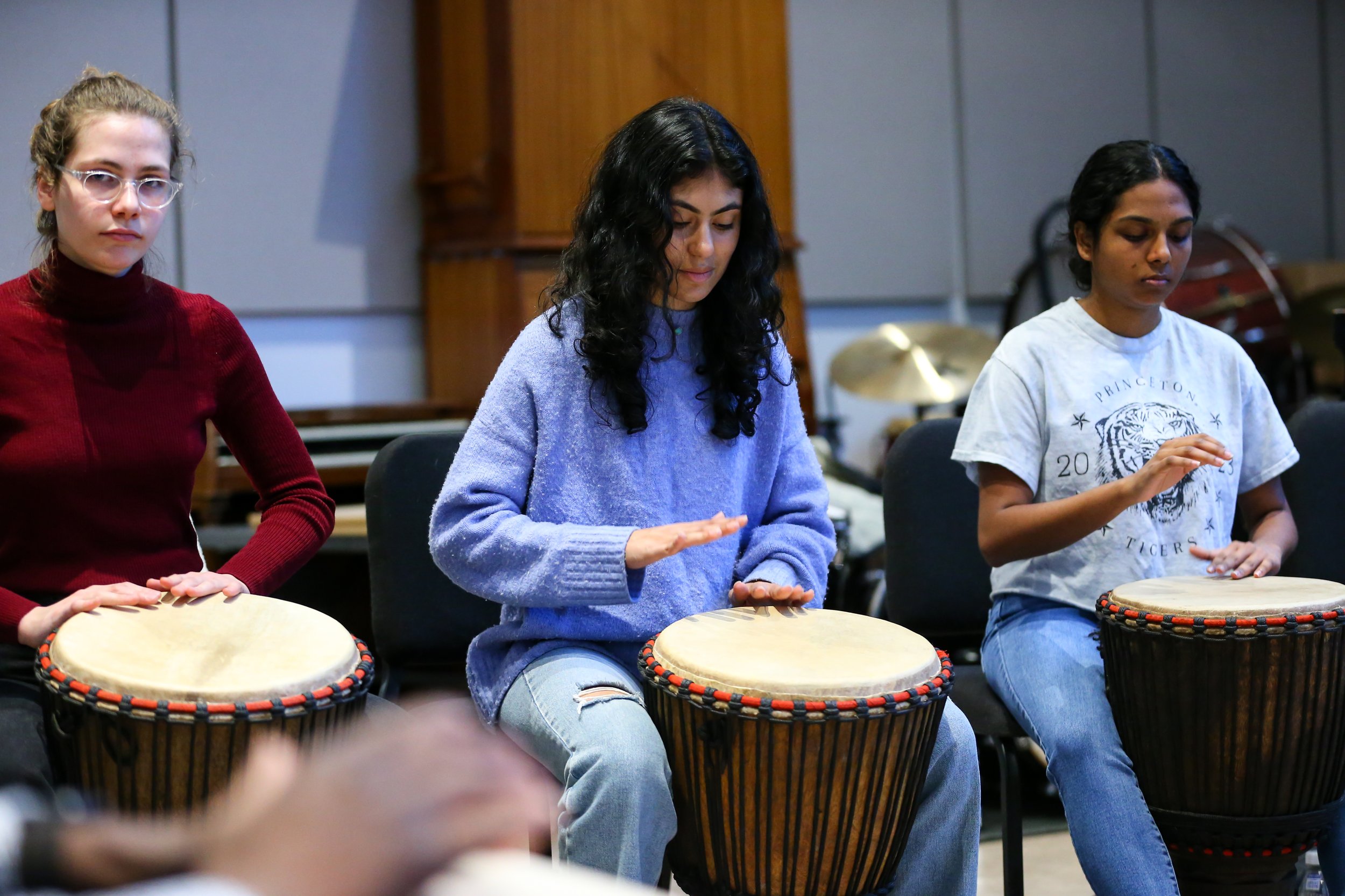 Students play the djembe drum in a Woolworth Center classroom.