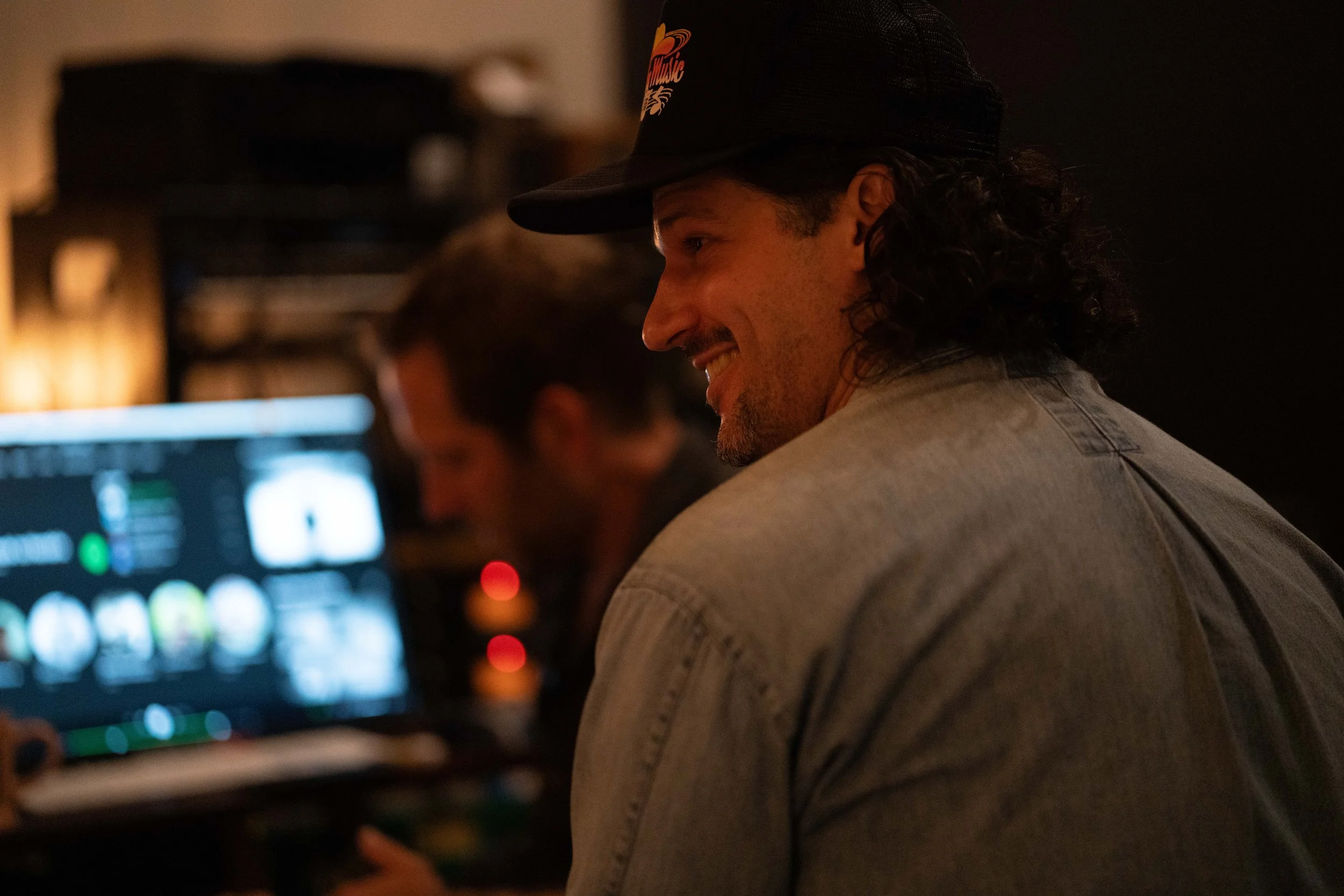 Country singer smiling in full color photo in a music studio while working on mixing a song.
