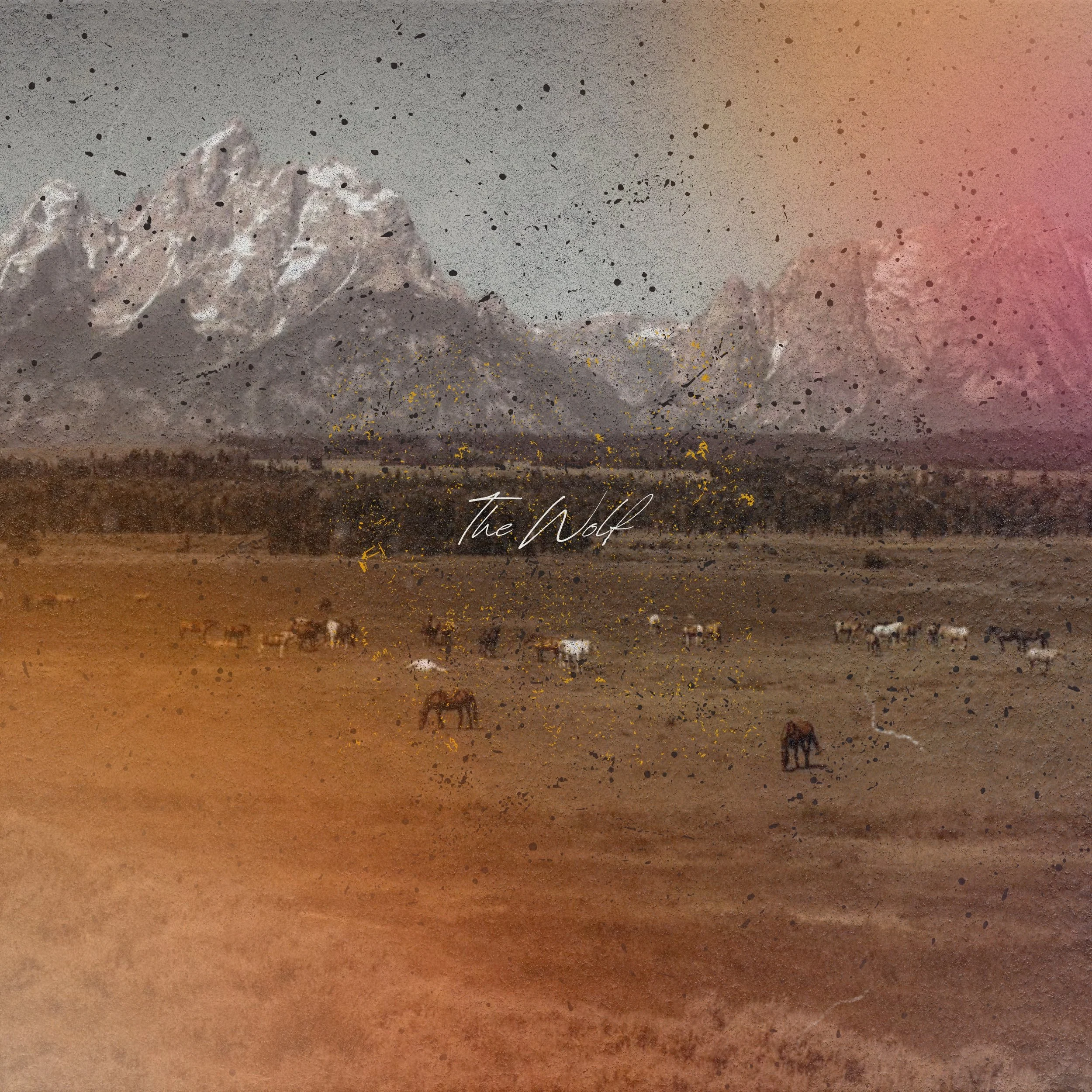Photo of a herd of horses dotted across a field in front of the mountains in Montana used as an album cover for a country album.