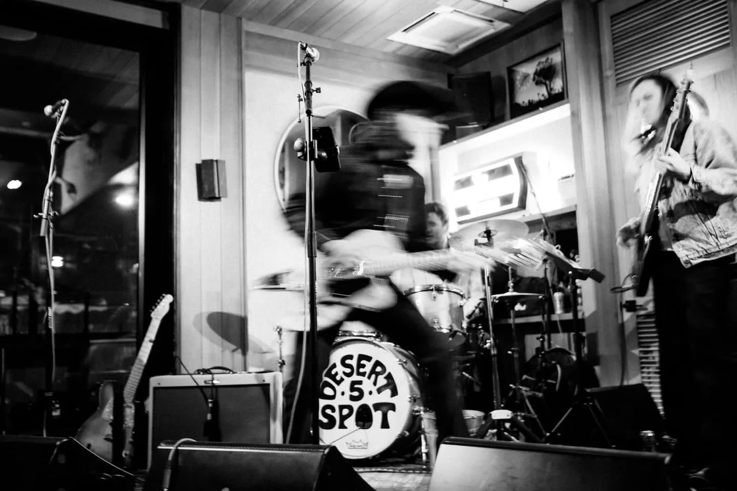 Blurred black and white image of a country band playing on stage at Desert Spot 5.