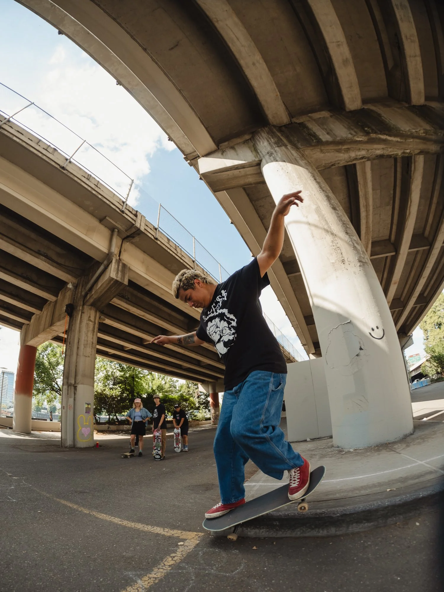 person skateboarding ledge under highway.
