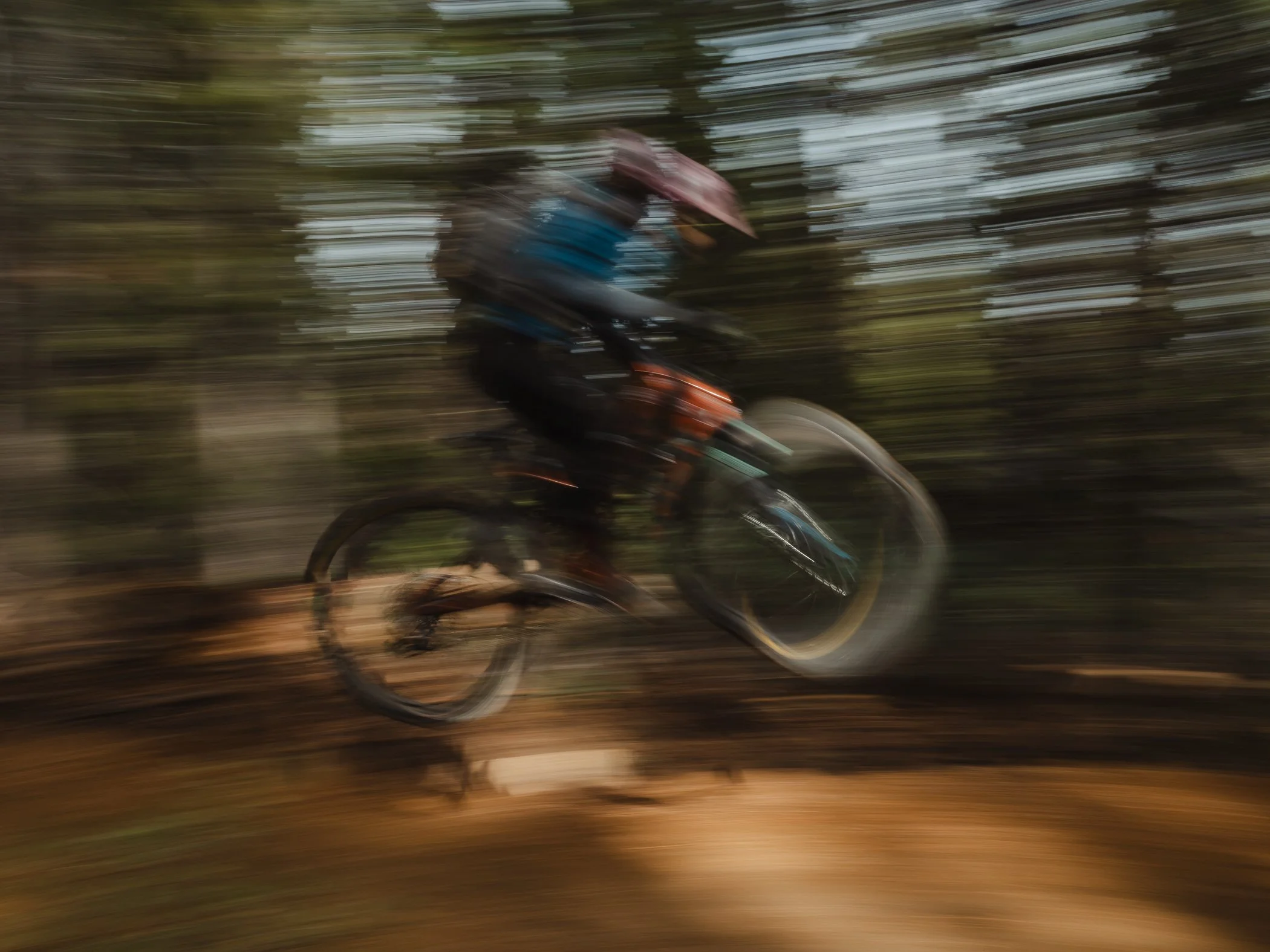 person mountain biking going off jump.