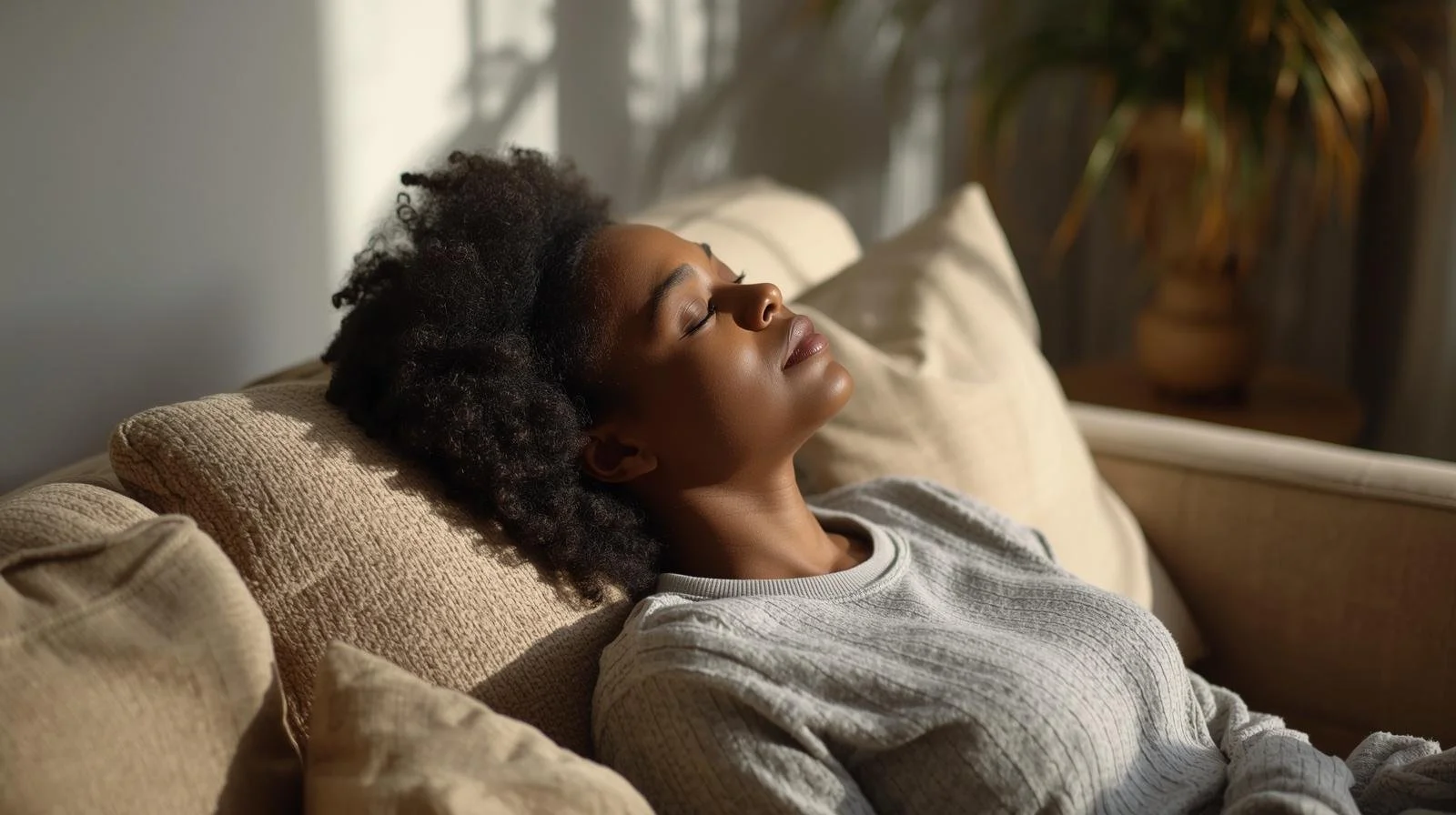 Black woman with eyes closed, taking a moment of quiet to calm her nervous system after virtual therapy for trauma in Chicago
