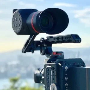 Camera mounted on a stabilizer rig with a scenic outdoor background.