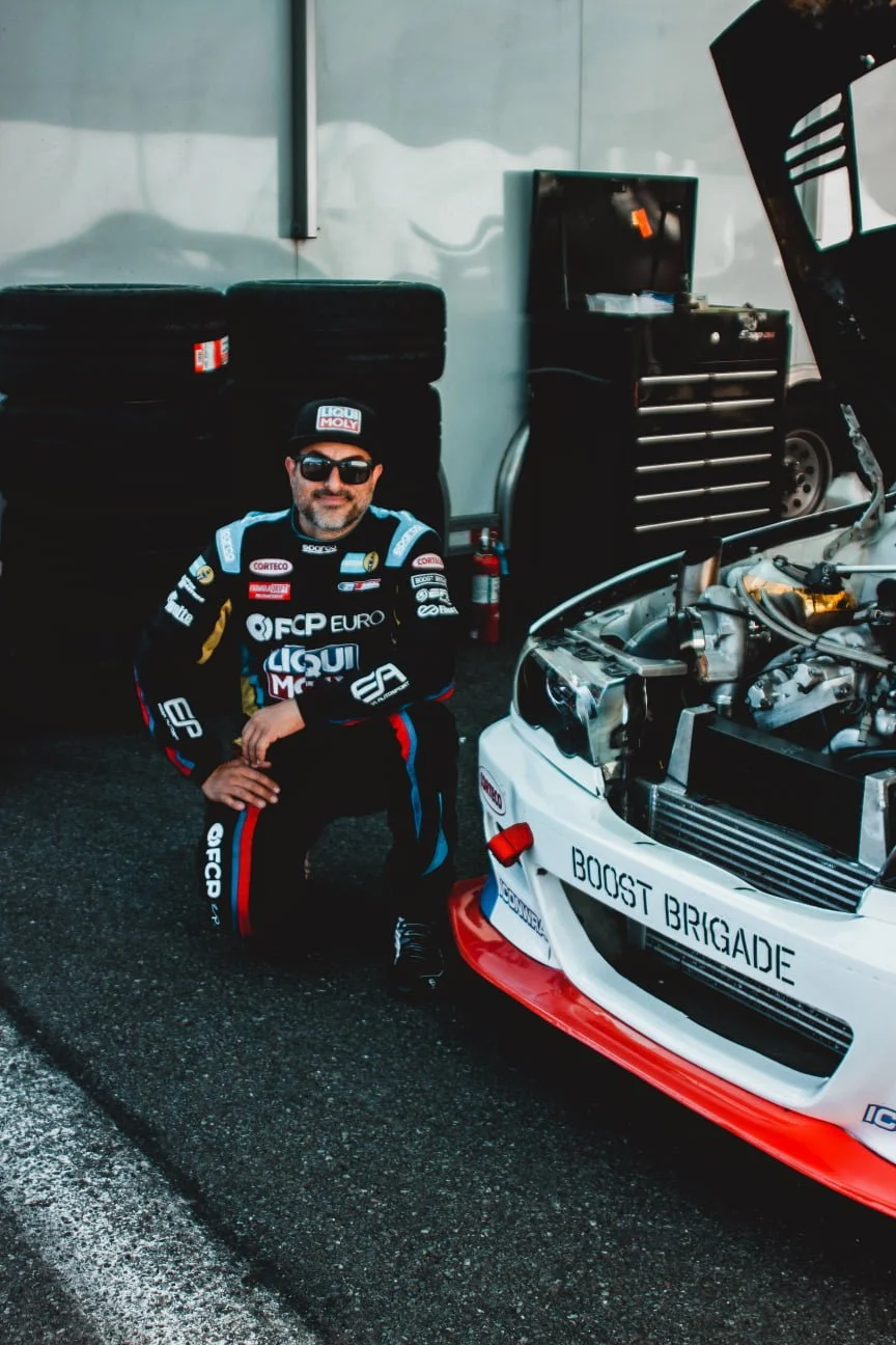Drift Racer Michael Essa kneeling next to his BMW at Formula Drift
