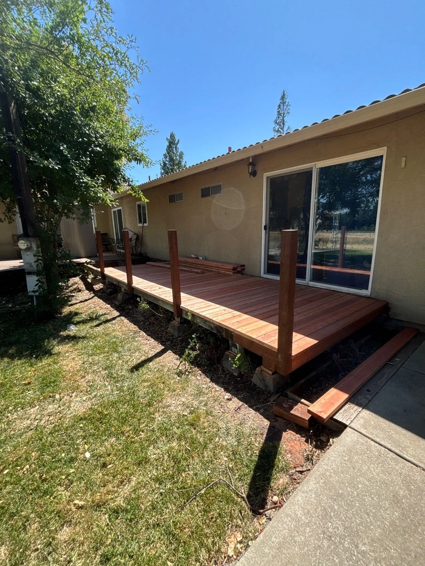 Rebuilt deck with new railings and steps seen from the yard in Sacramento