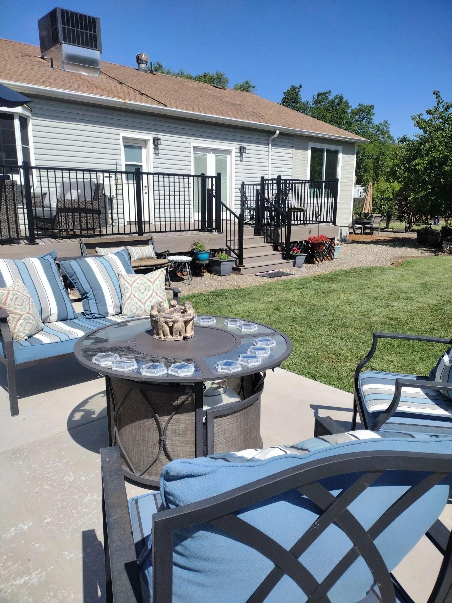 New composite deck with black railings behind a backyard patio in Rio Linda