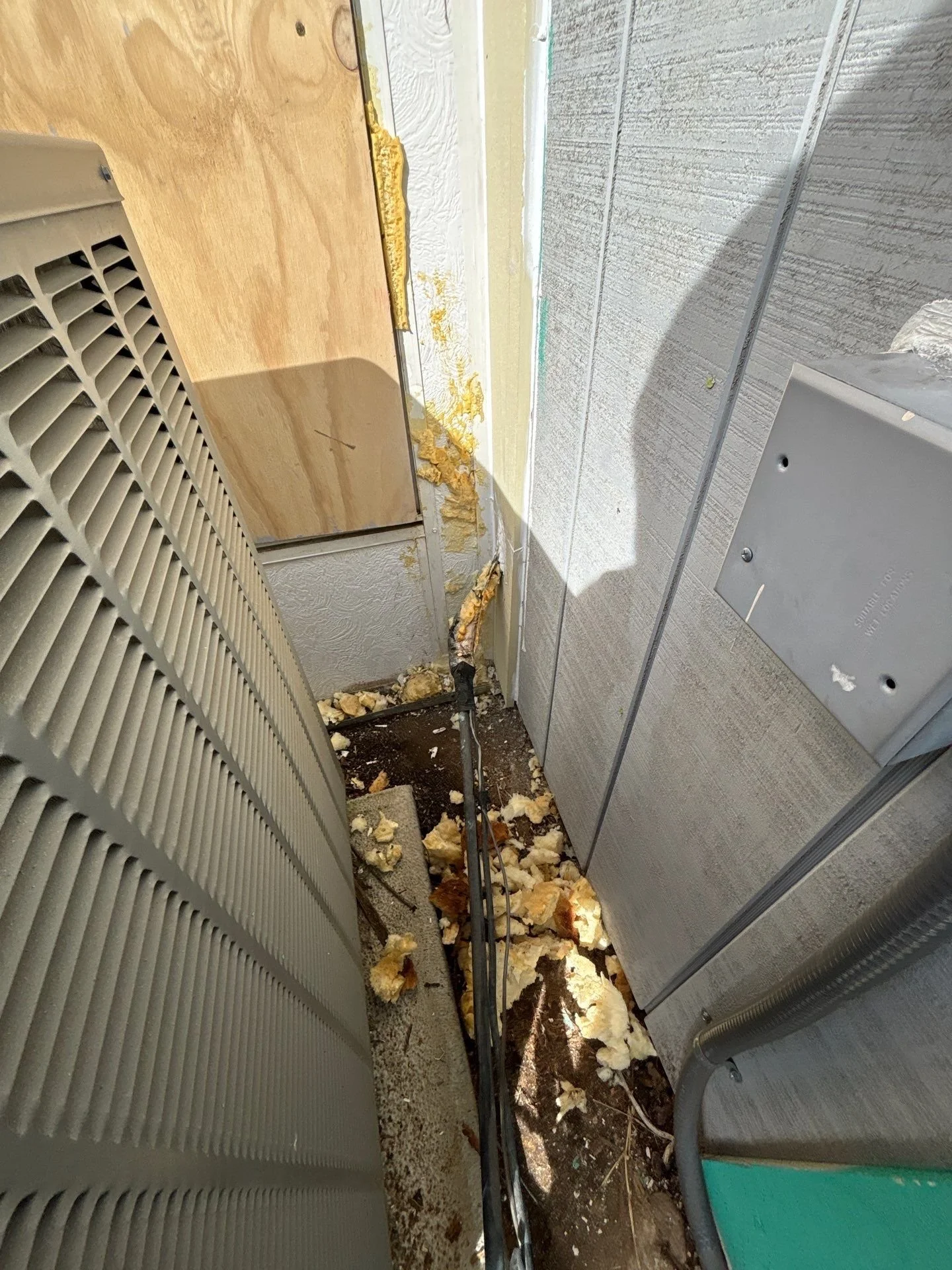 Dry rot exposed behind an AC unit before siding repair in Antelope