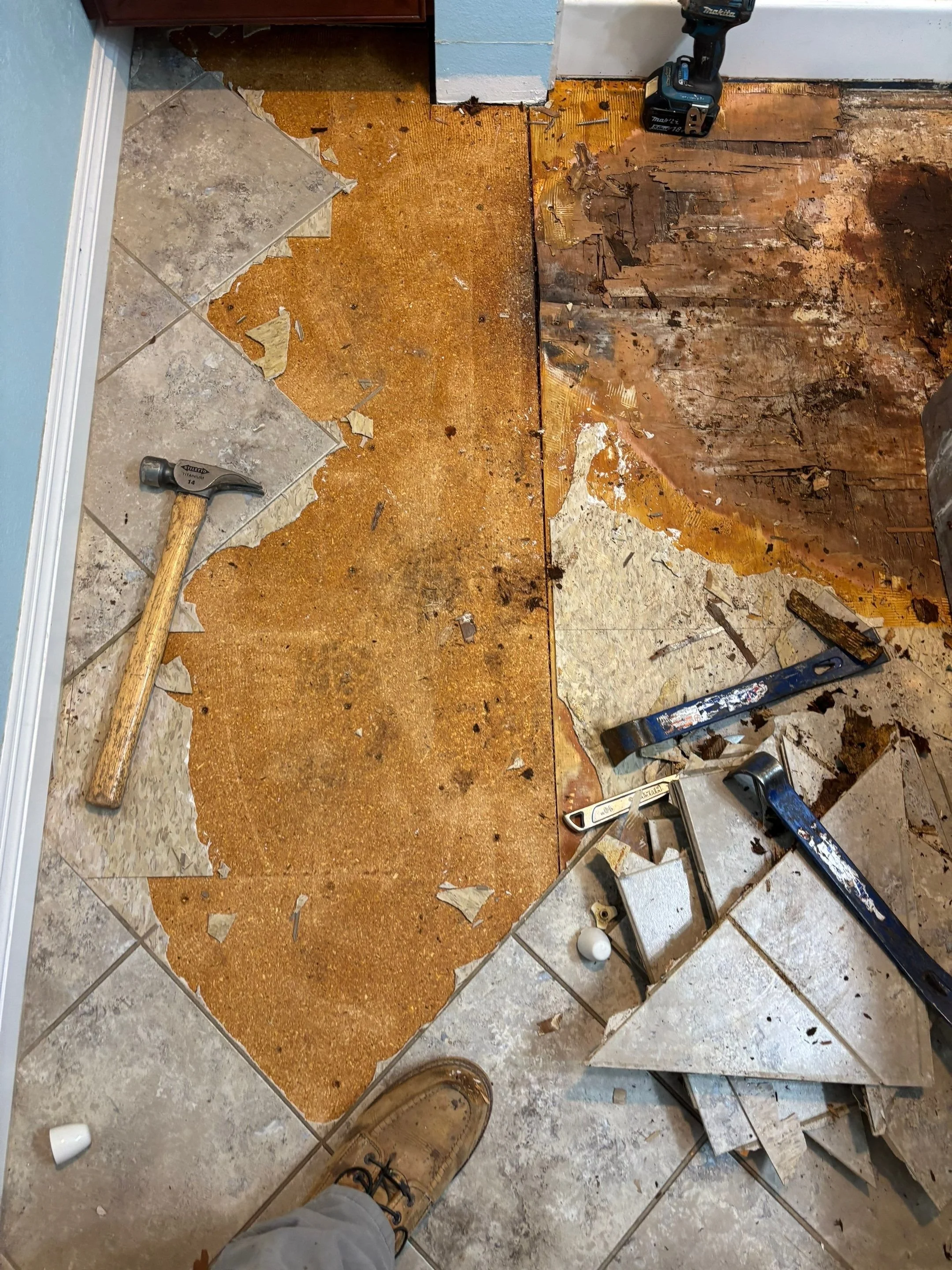 Old bathroom tile being torn out to reach rotted subfloor in Sacramento
