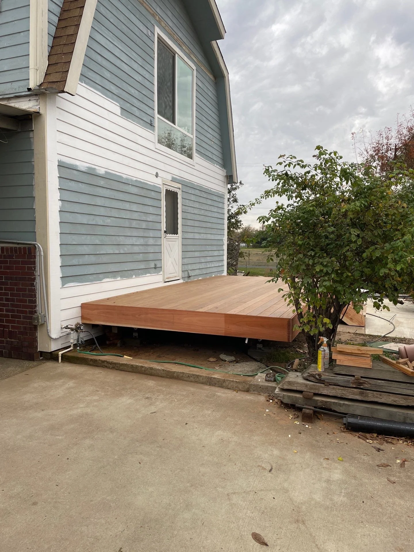 New deck framed and decked while siding replacement is in progress in Rio Linda