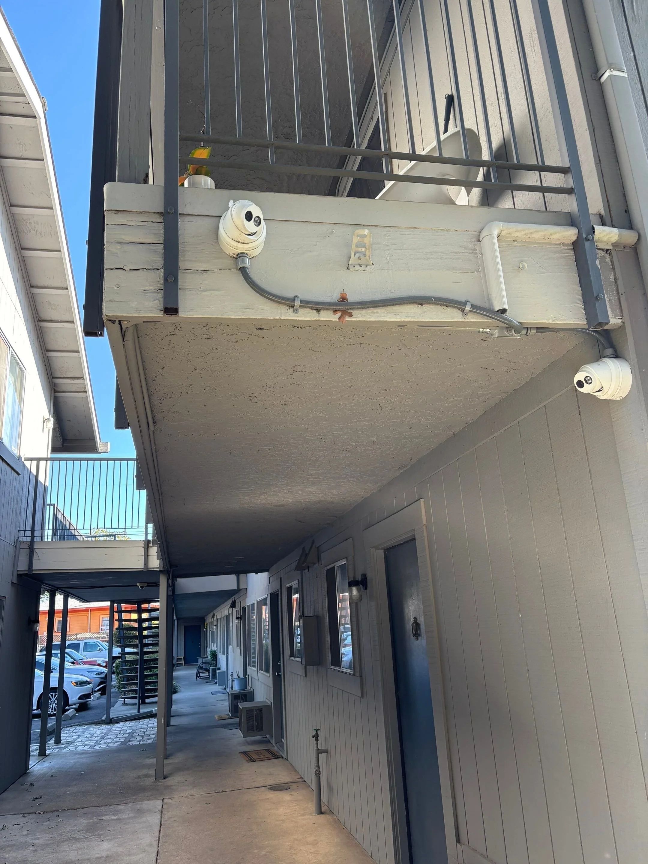 Weathered fascia board and underside of an apartment balcony before dry rot repair in Sacramento