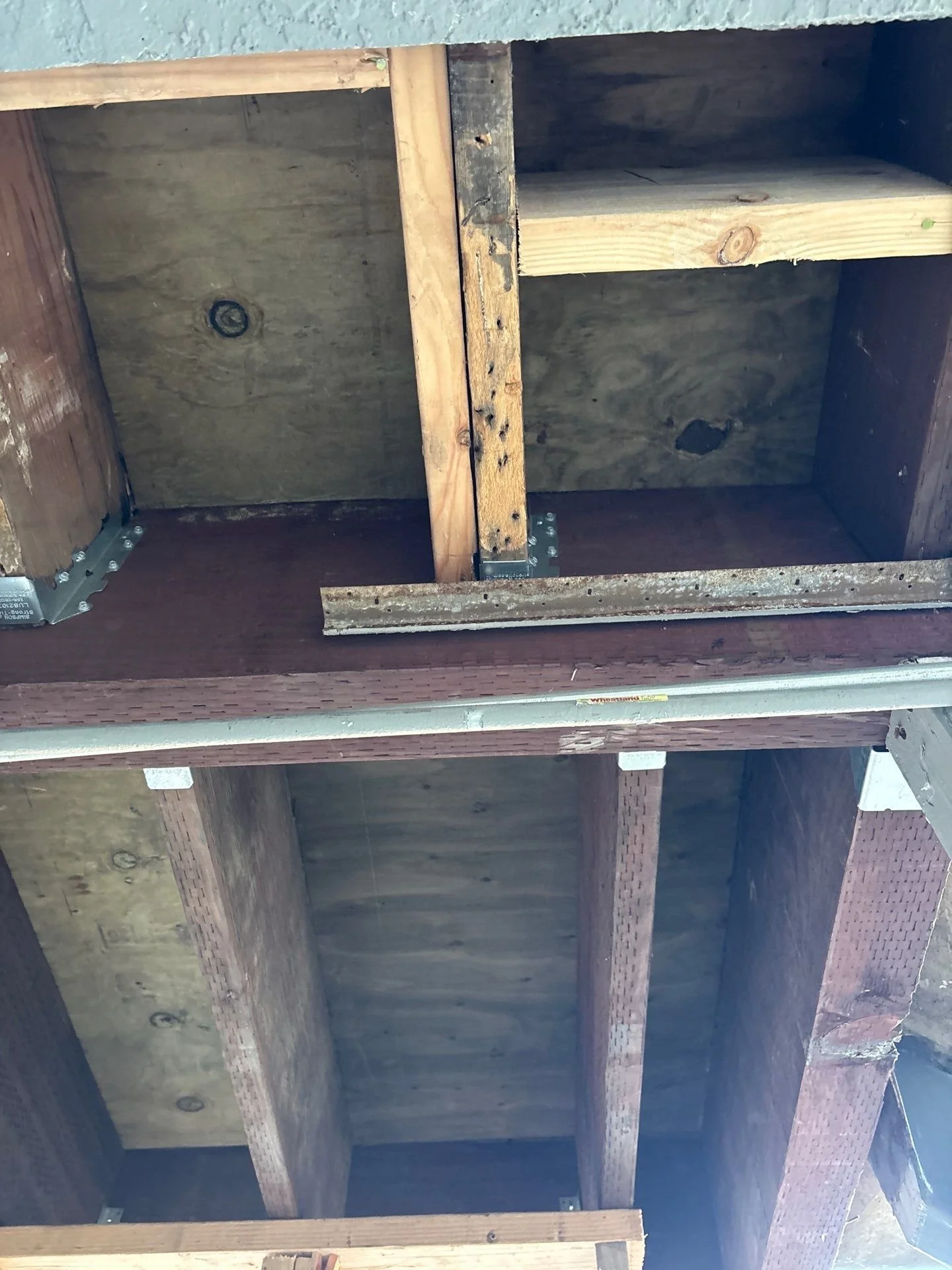 Exposed balcony framing with decayed joists during dry rot repair in Sacramento