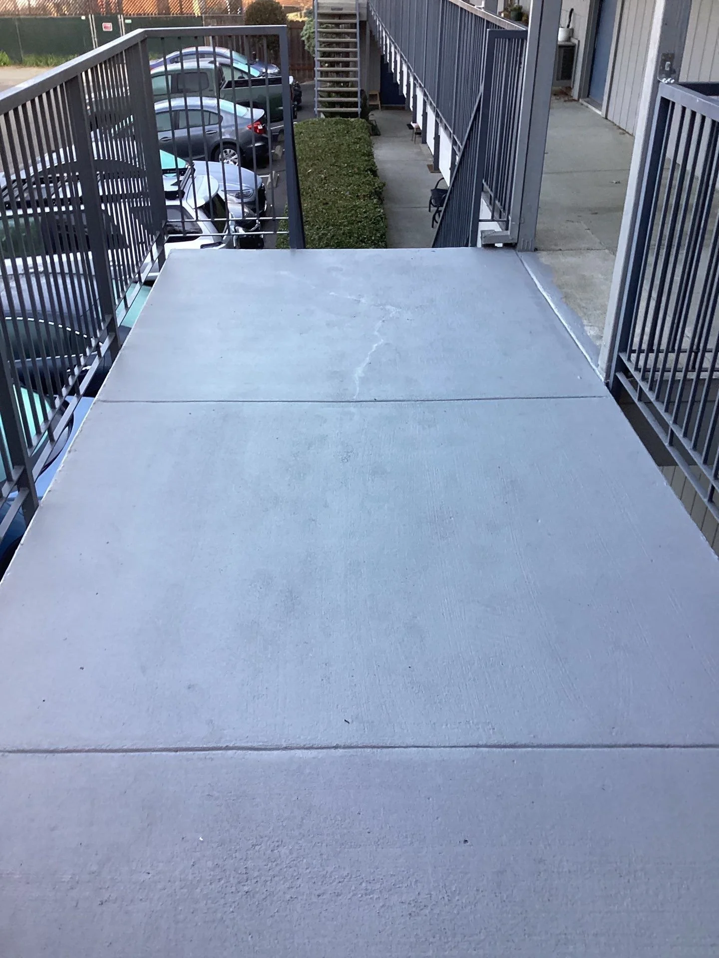 Finished apartment balcony walkway with dark metal railings in Sacramento