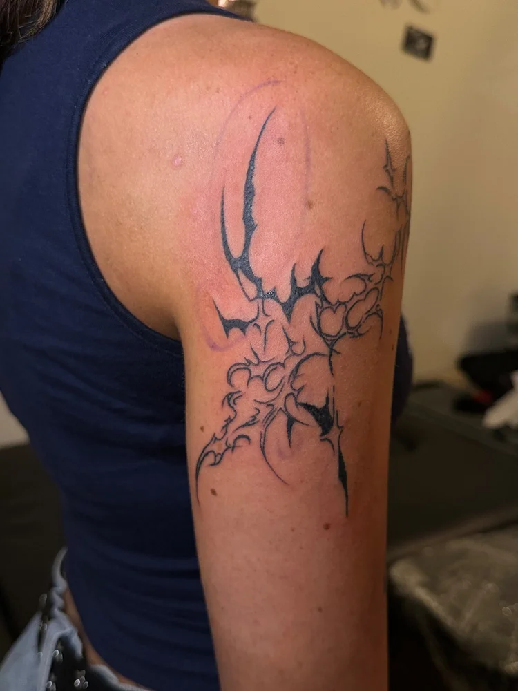 Abstract black line tattoo on the upper arm by Summer