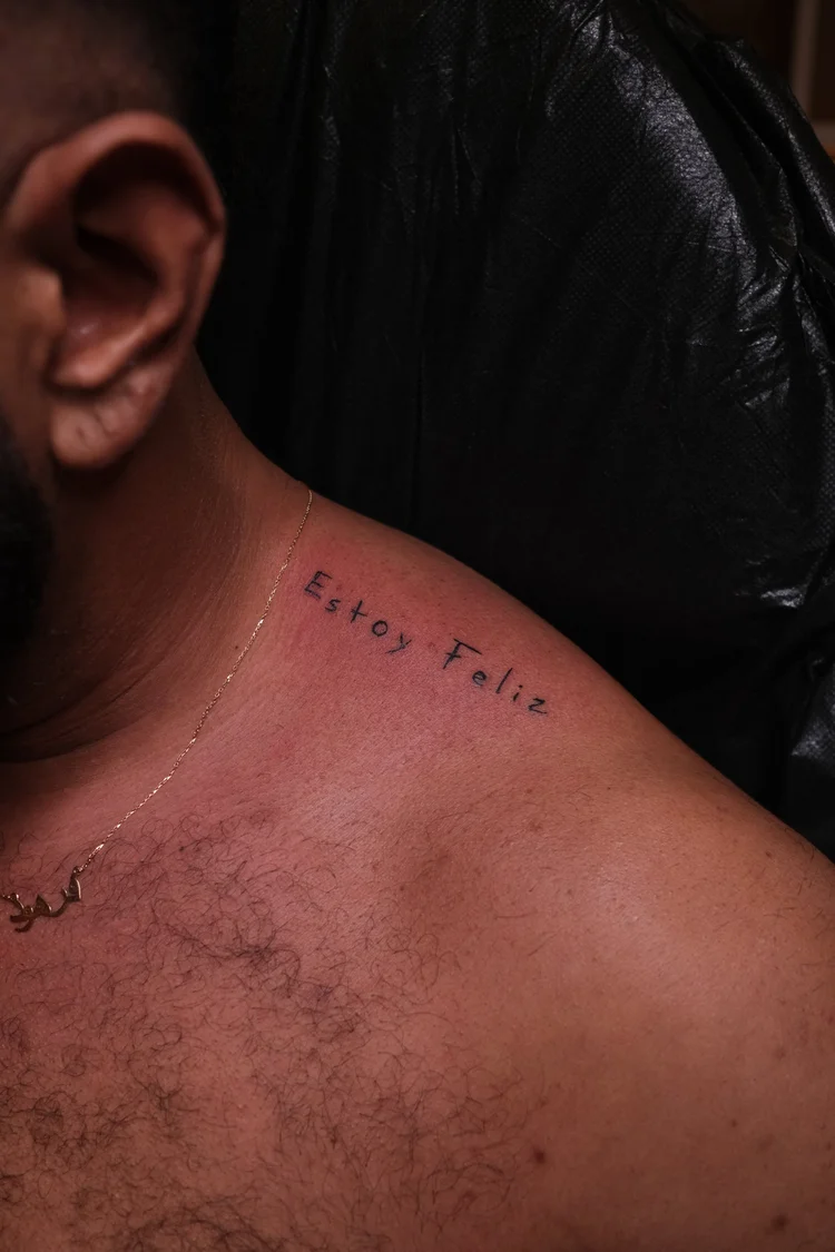 Estoy Feliz script tattoo on a shoulder by Eli