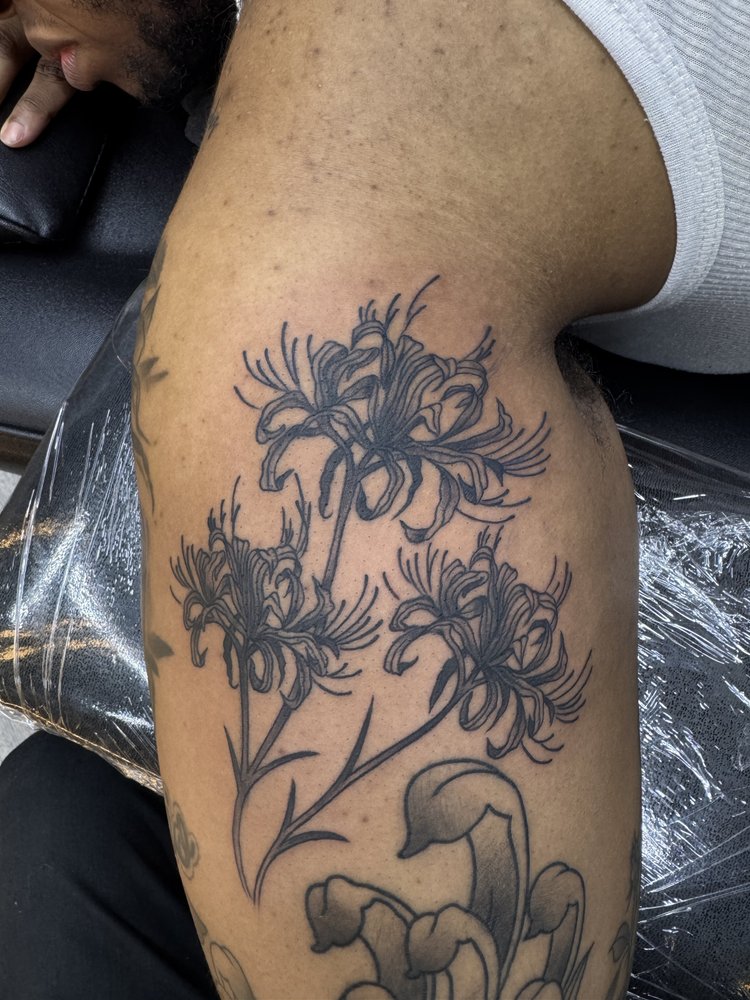 Large black and grey floral tattoo on the upper arm and shoulder by Daniel