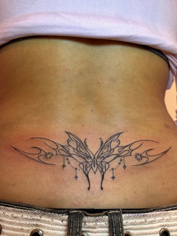 Ornate symmetrical butterfly tattoo with hanging stars by Summer