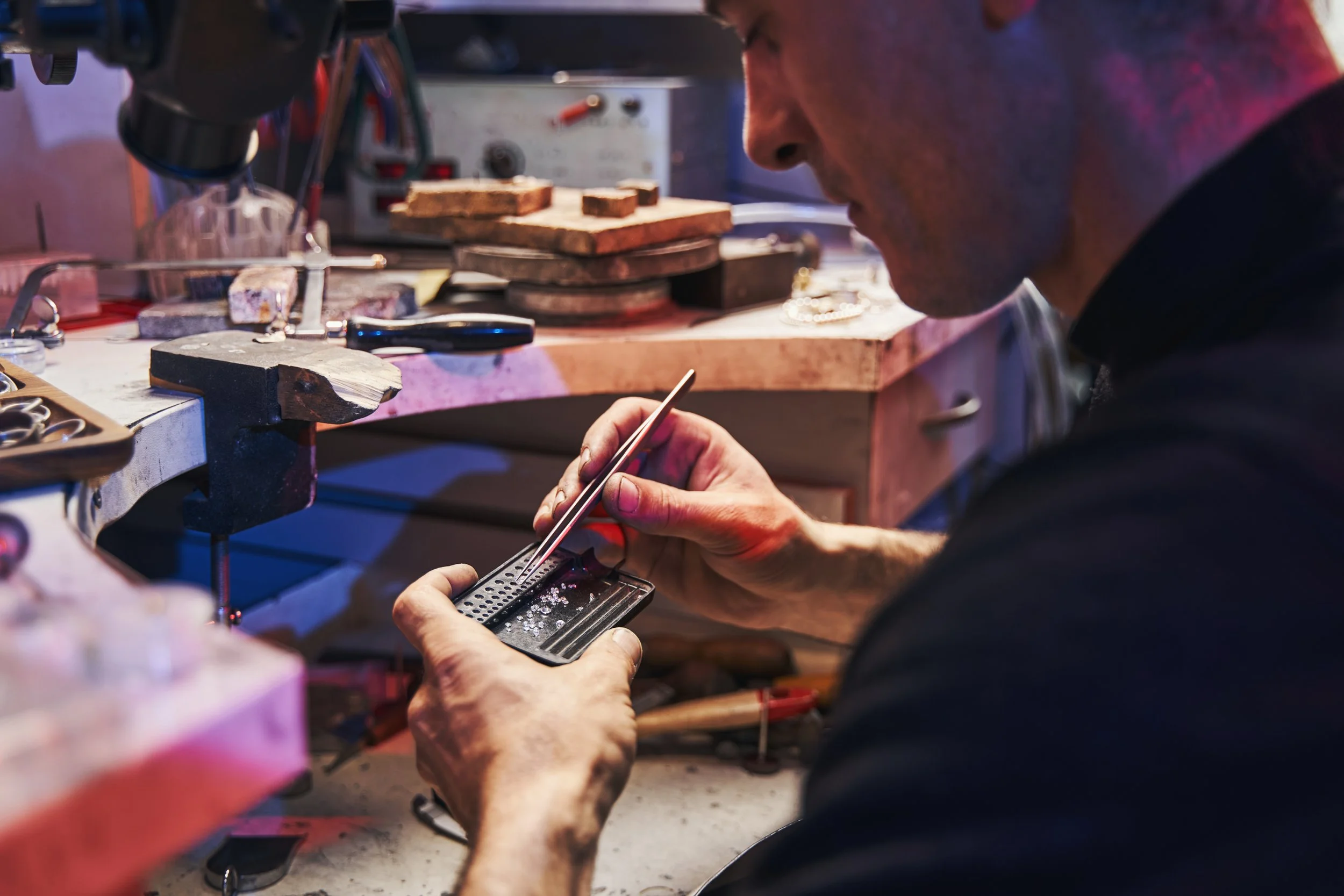 jeweler picking lab grown and real diamonds